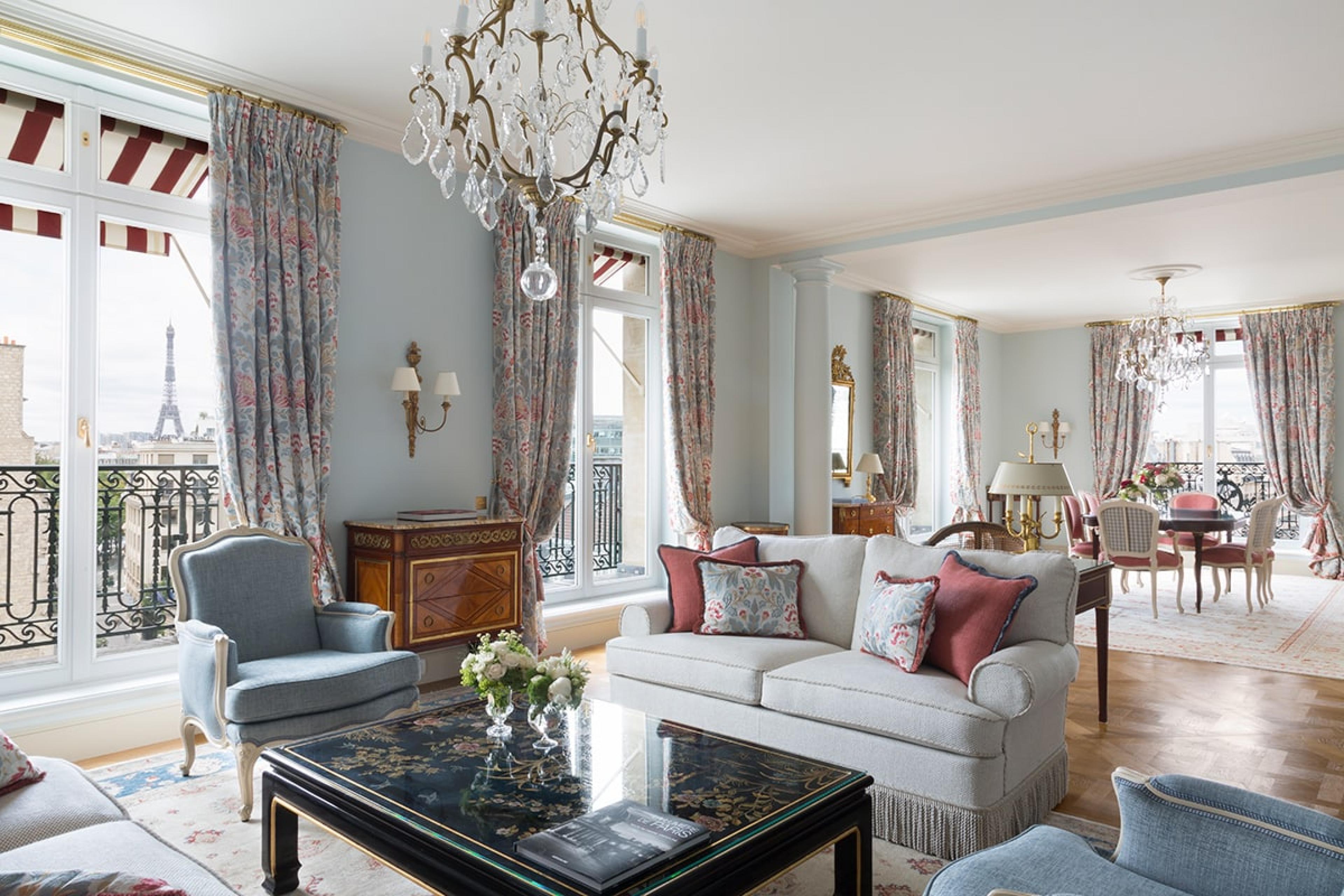 hotel suite in paris with traditional elegant furnishings, a chandelier, and windows with view of eiffel tower