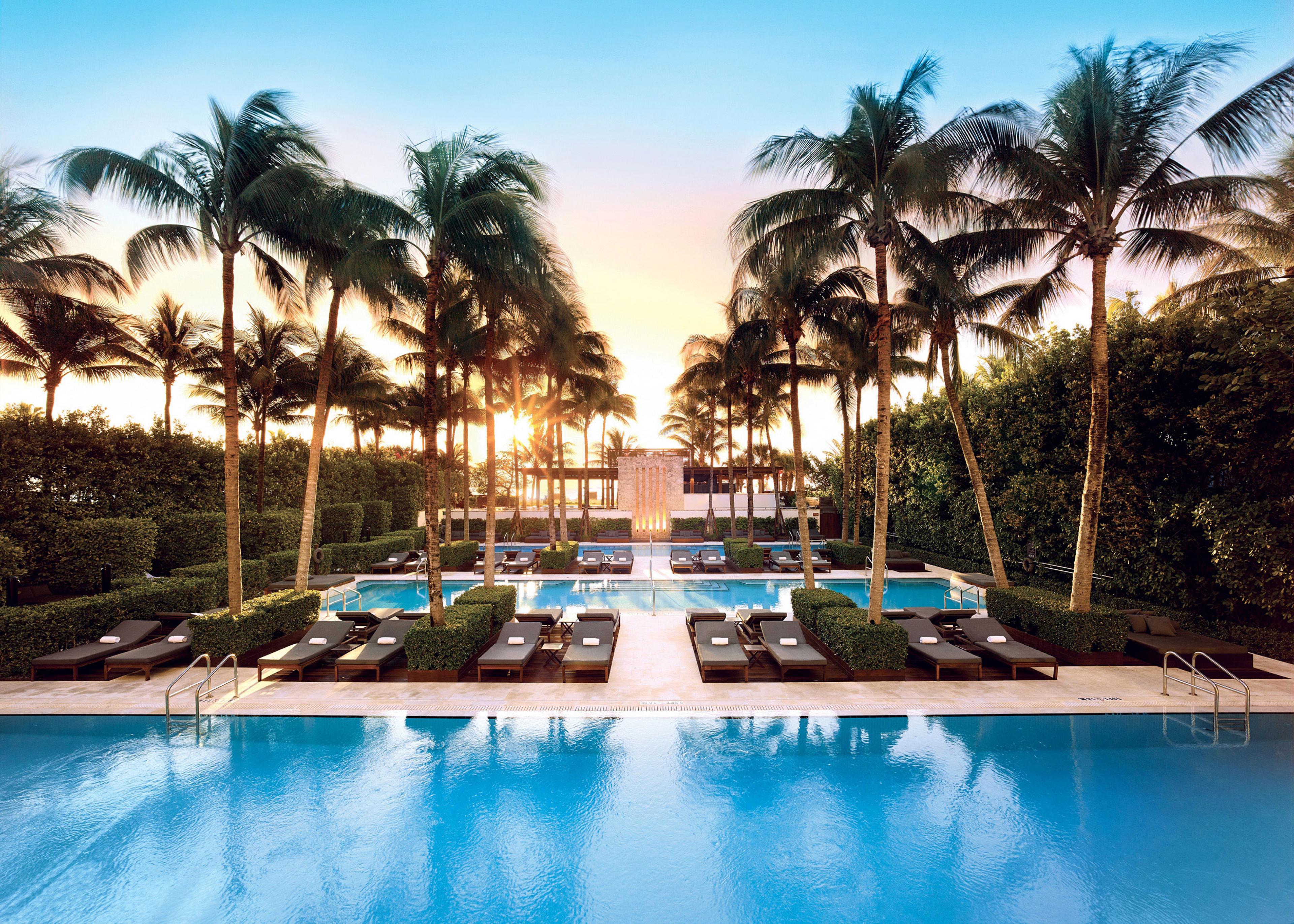 two large outdoor pools with palm trees