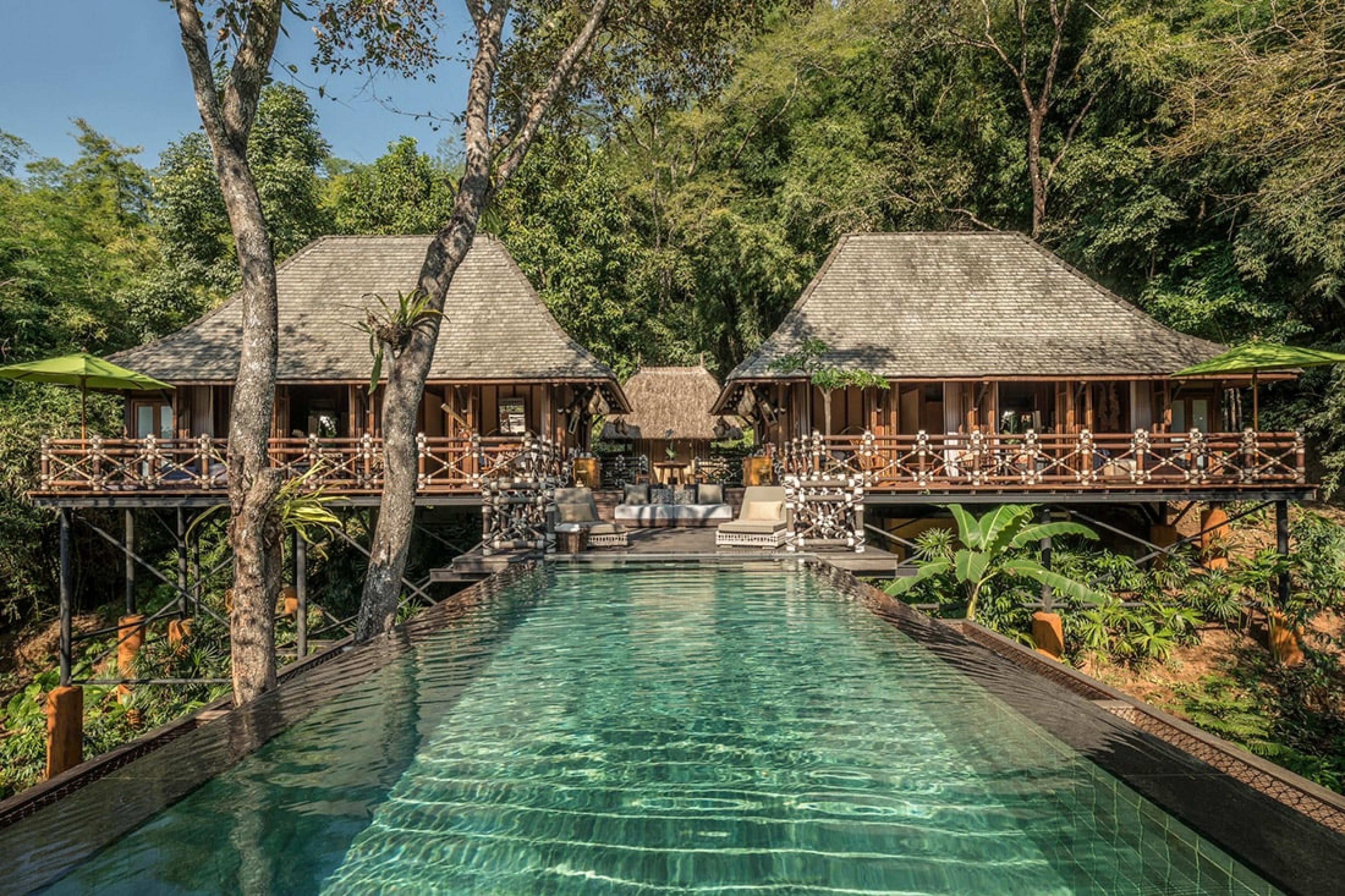 pool in jungle with wooden building in background