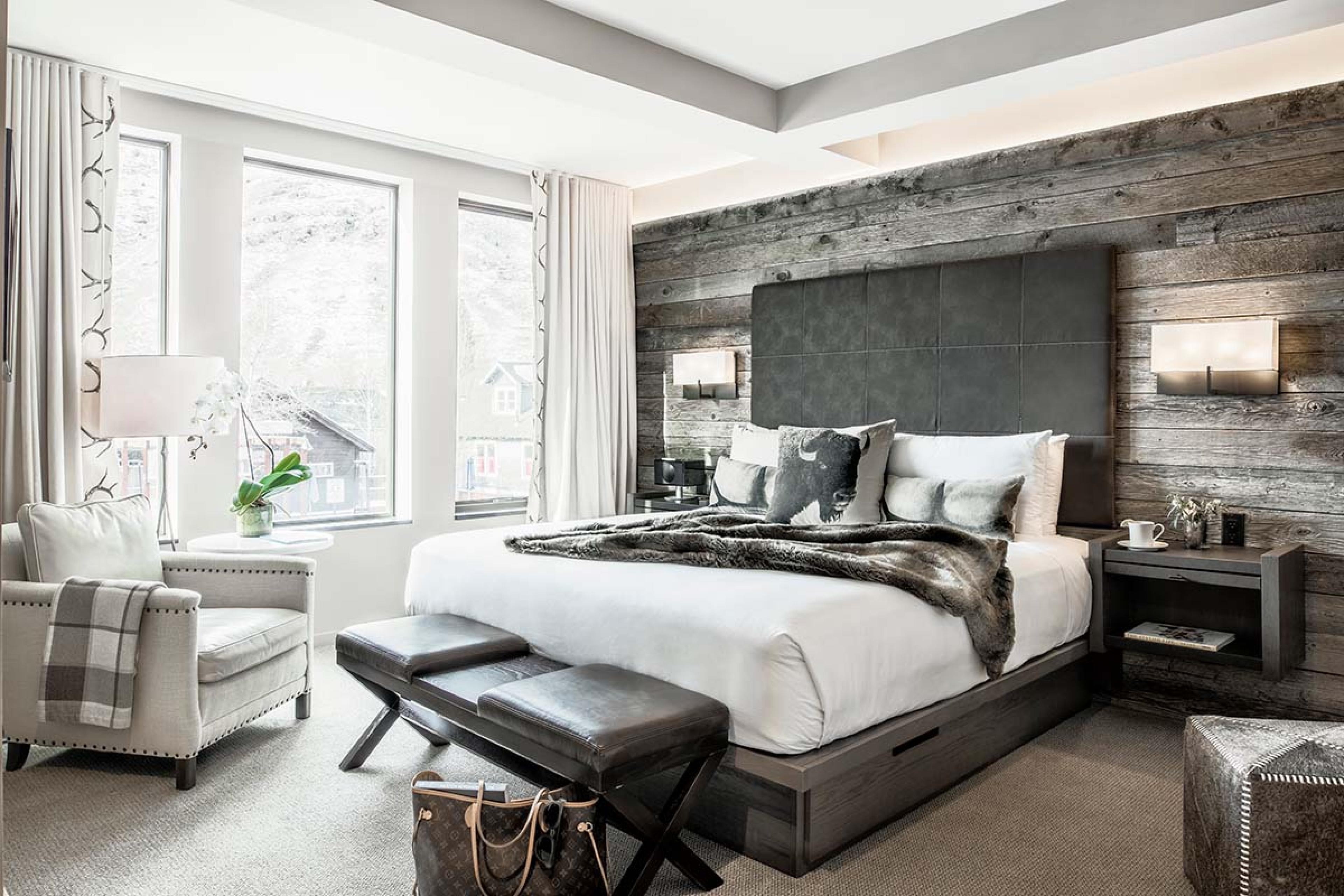 bedroom with a gray backboard and gray faux fur throw and a big windows