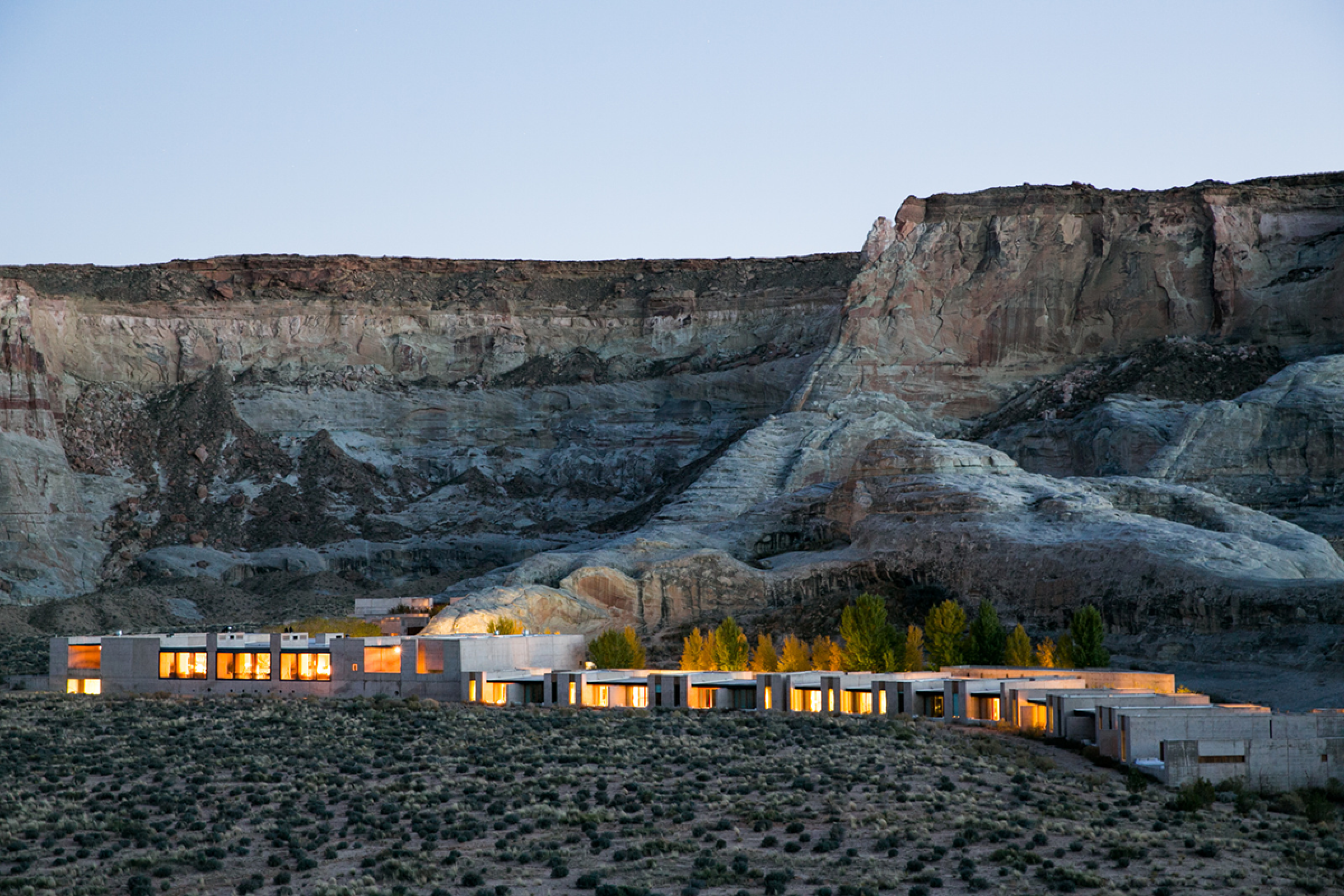 View of the hotel lit up at dusk. The desert setting and remoteness of the location.