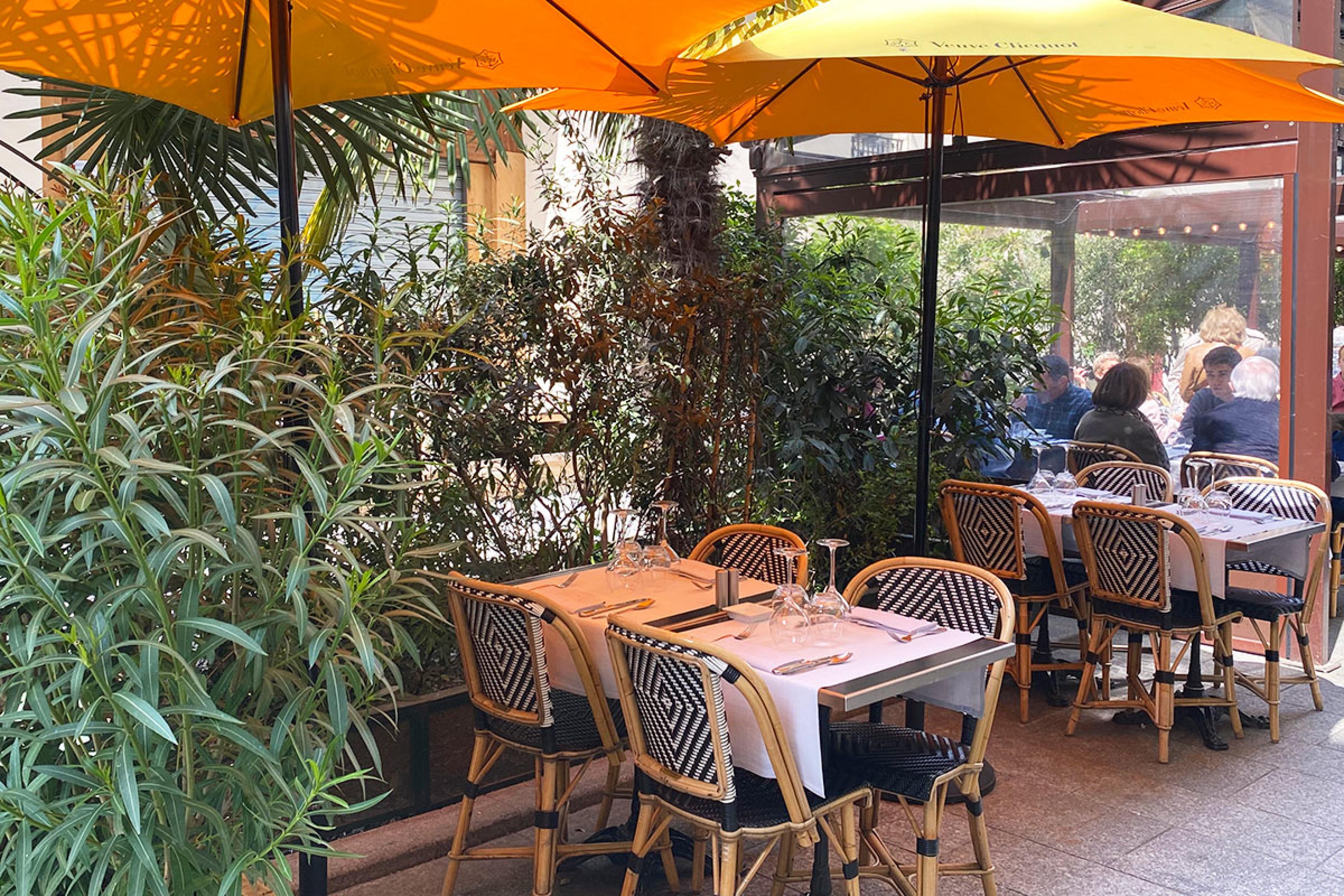 la recamier paris outdoor cafe seating under yellow umbrella