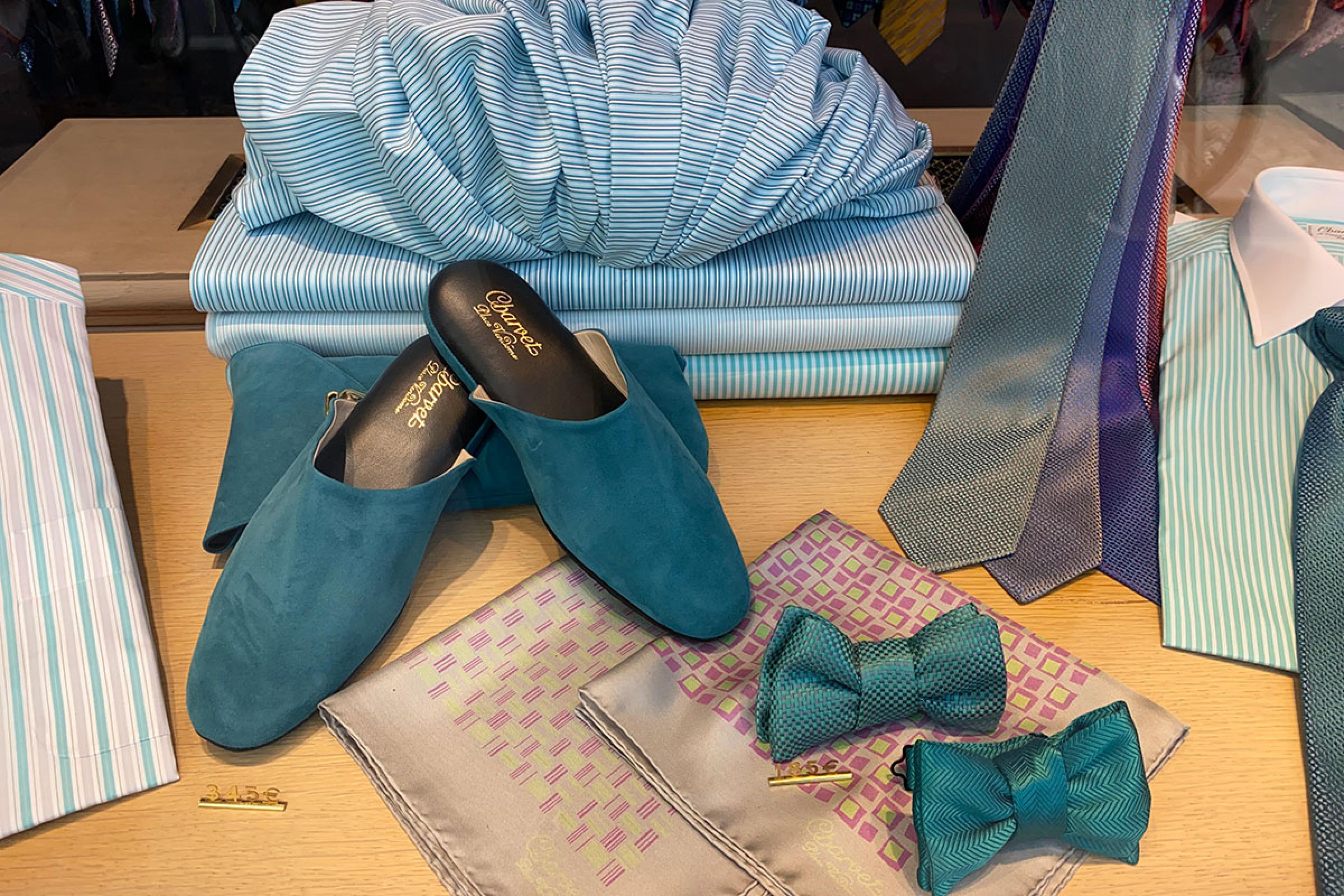 teal-blue bowties and matching shoes on display on a table in a boutique
