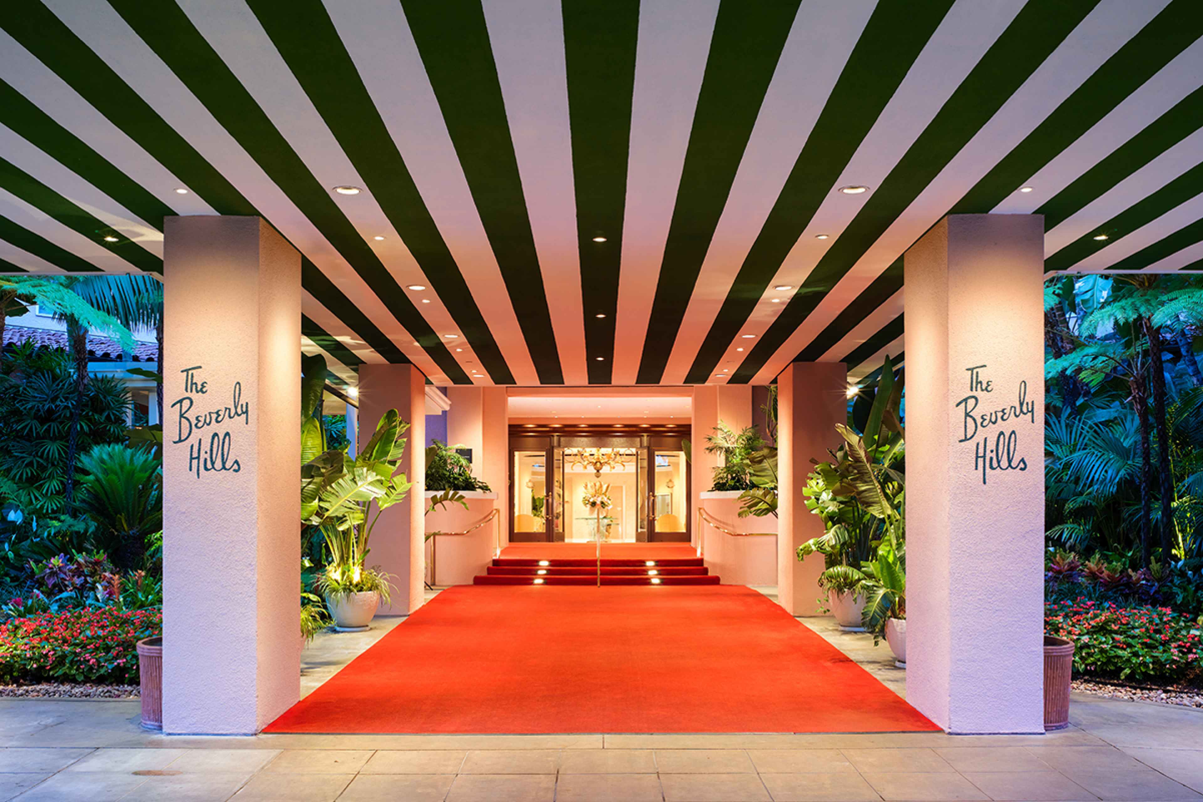 entrance to hotel with red carpet and brown and pink striped ceiling