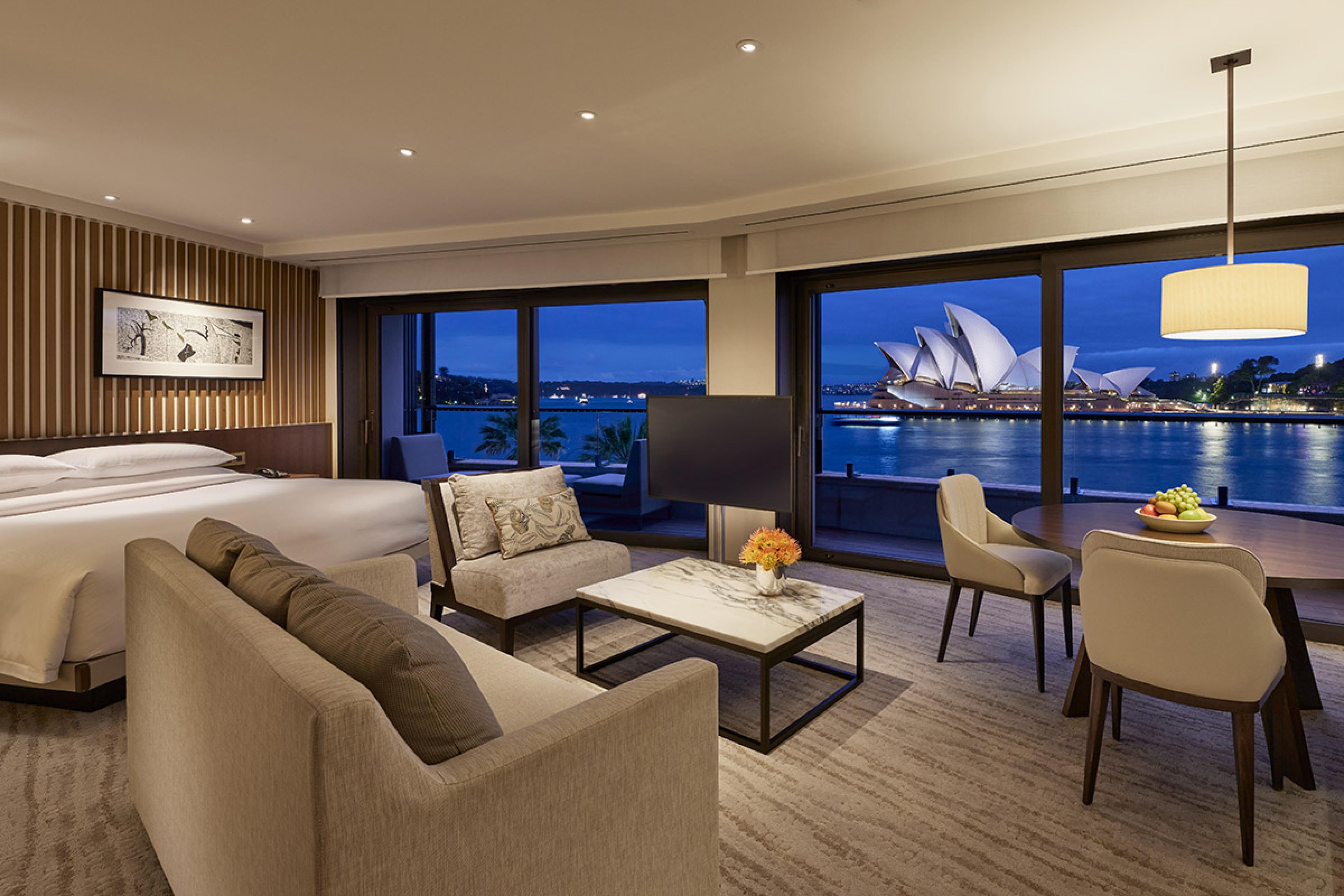 large hotel room with two huge windows overlooking sydney opera house