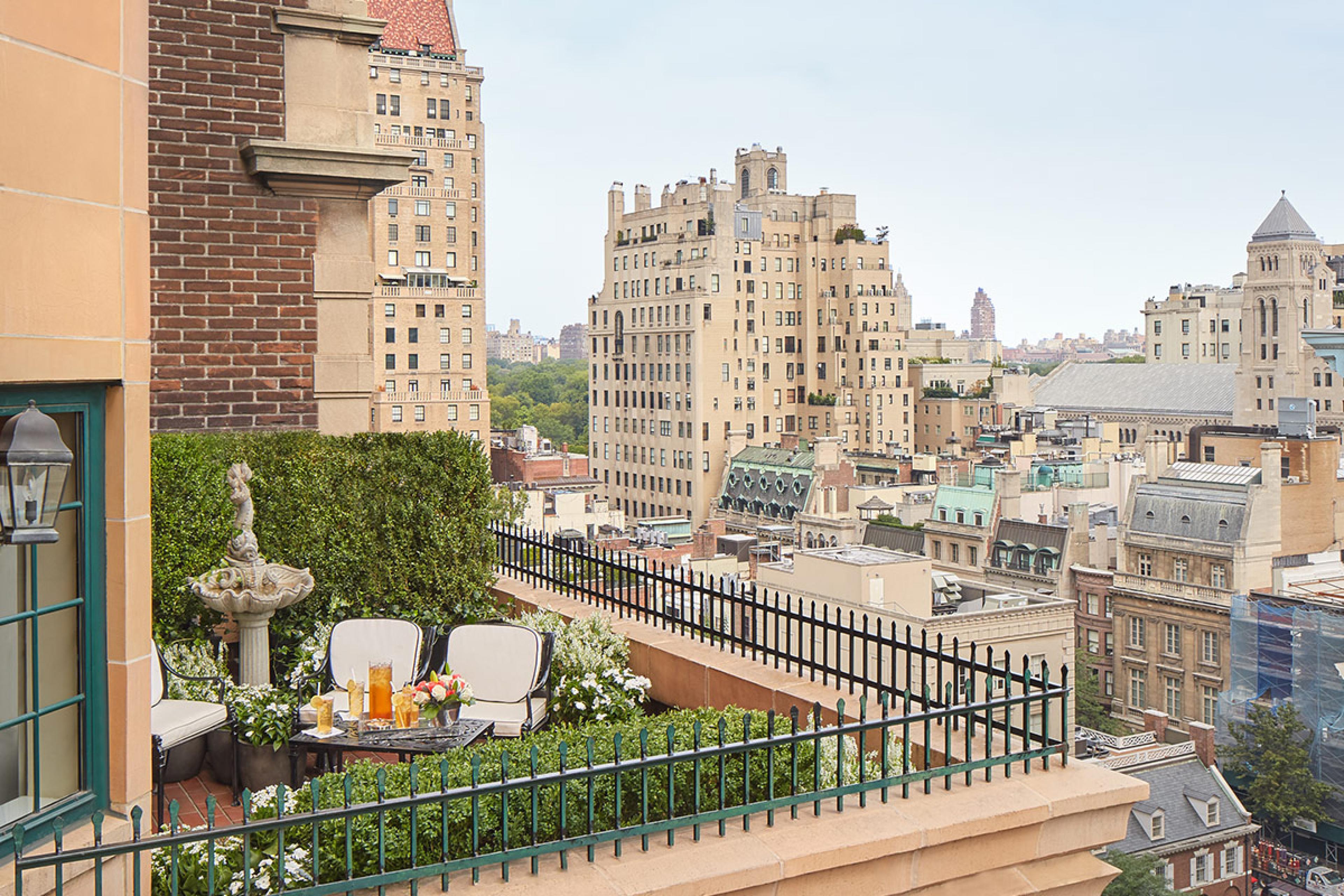 hotel terrace in nyc with seating with ivy and skyline views from brick building