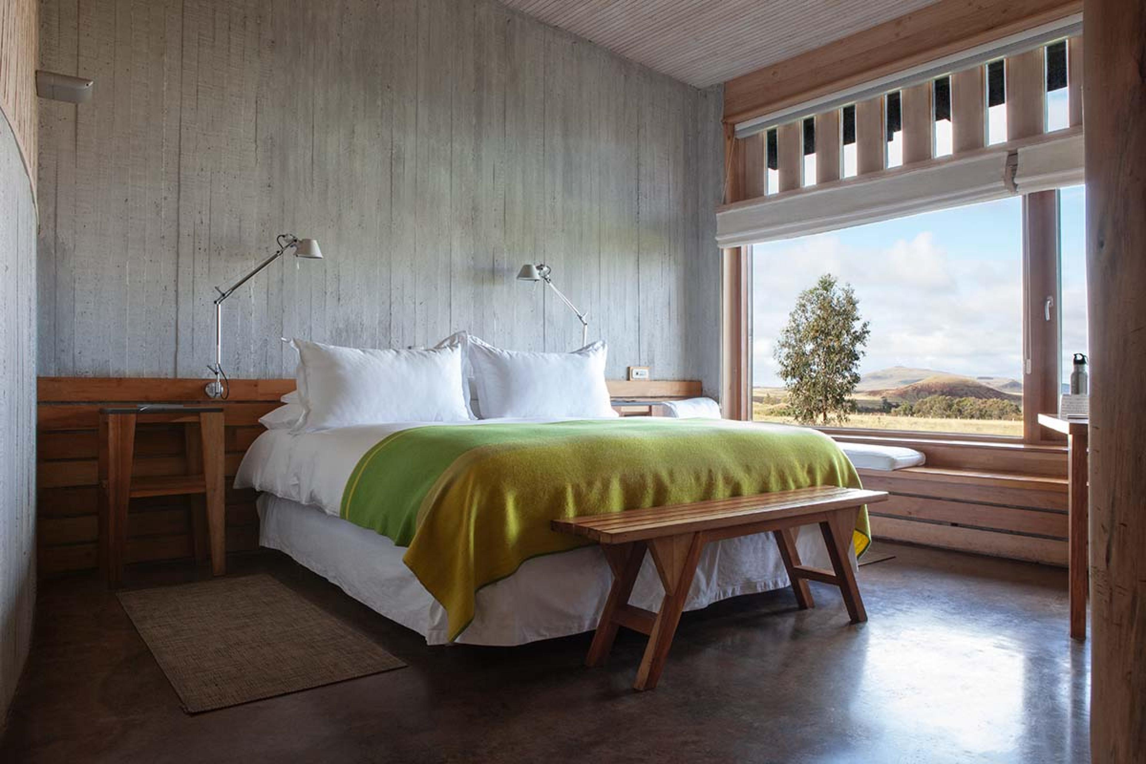 bedroom with simple wooden furniture and a white bed with bright green accents