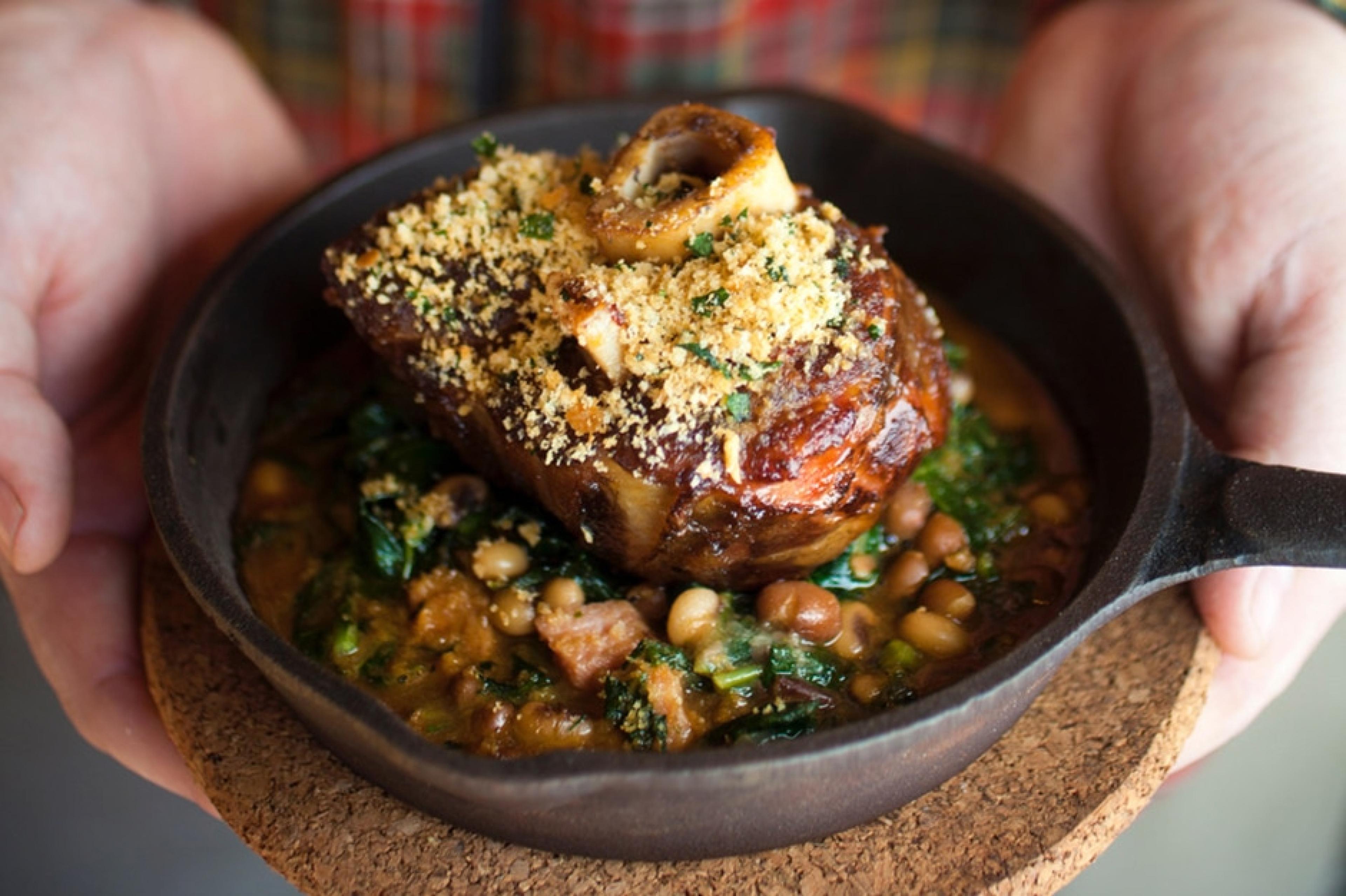 a skillet with pork on top of beans 