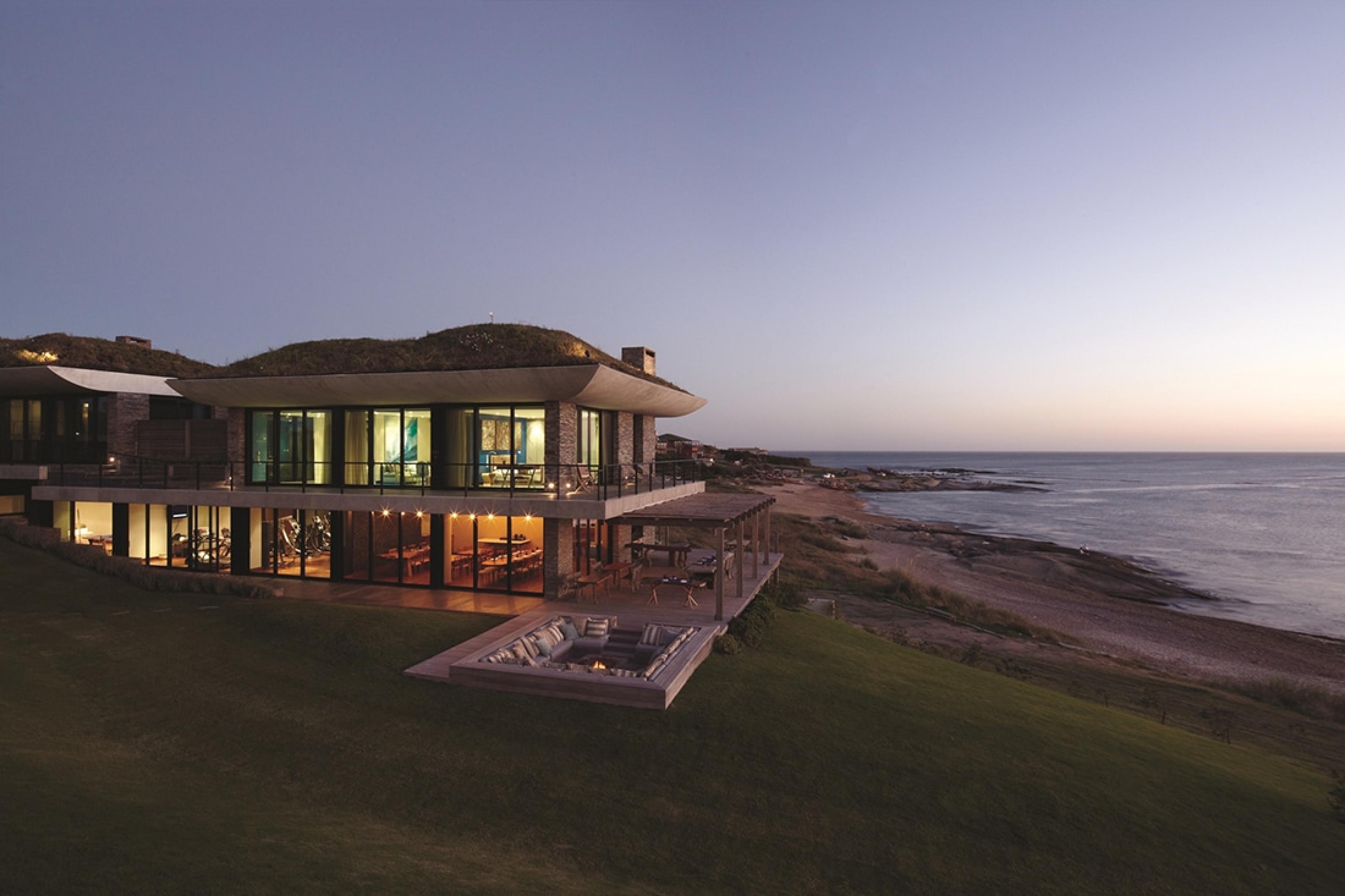 oceanfront two-story villa at night with art visible inside