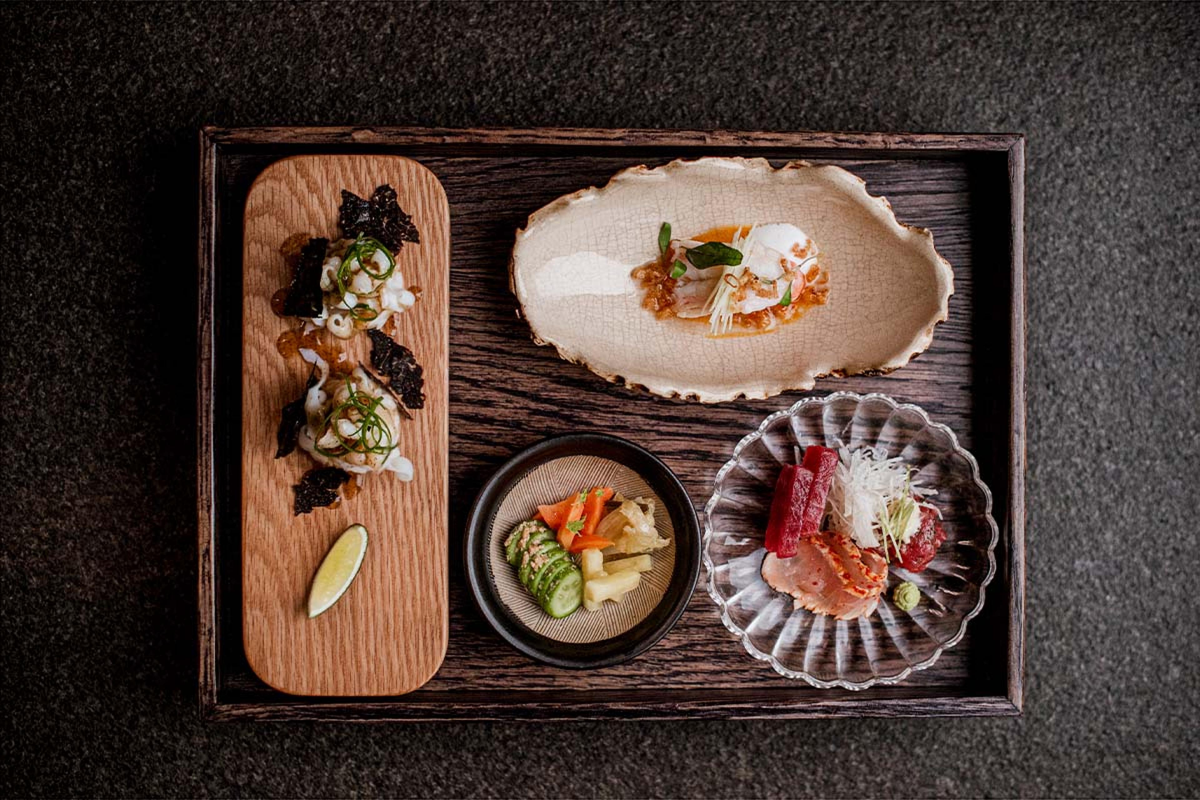 wooden tray with different dish shapes and raw fish