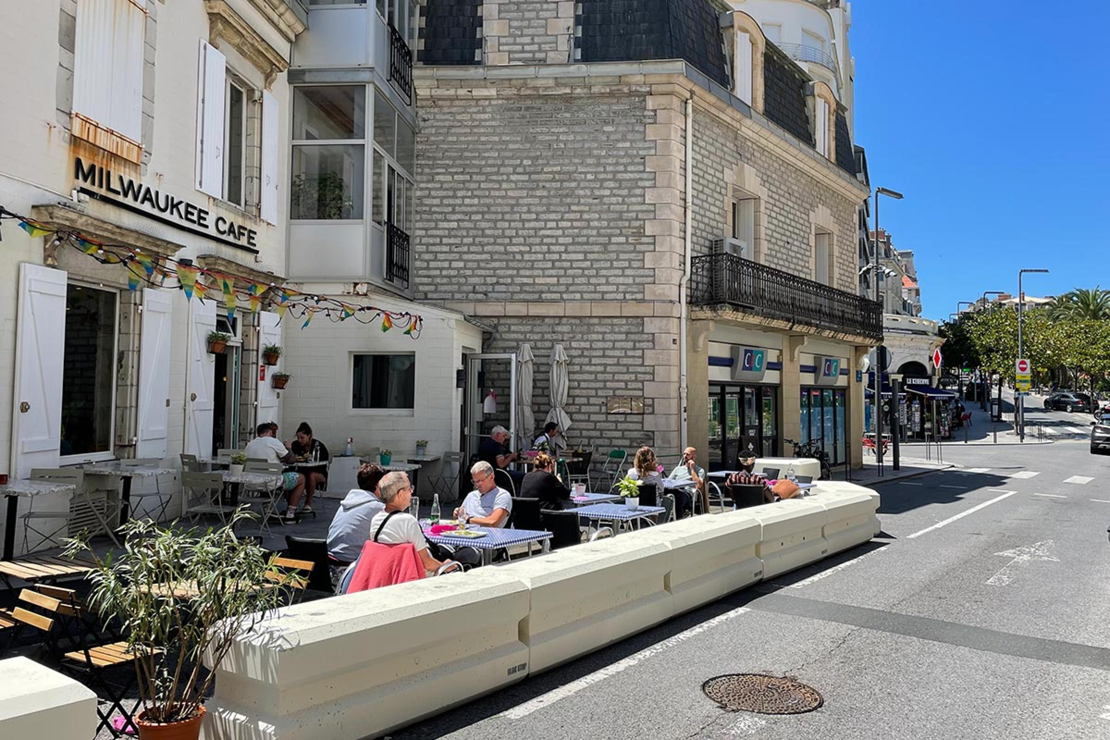 exterior of cafe on a street corner in france on a sunny day