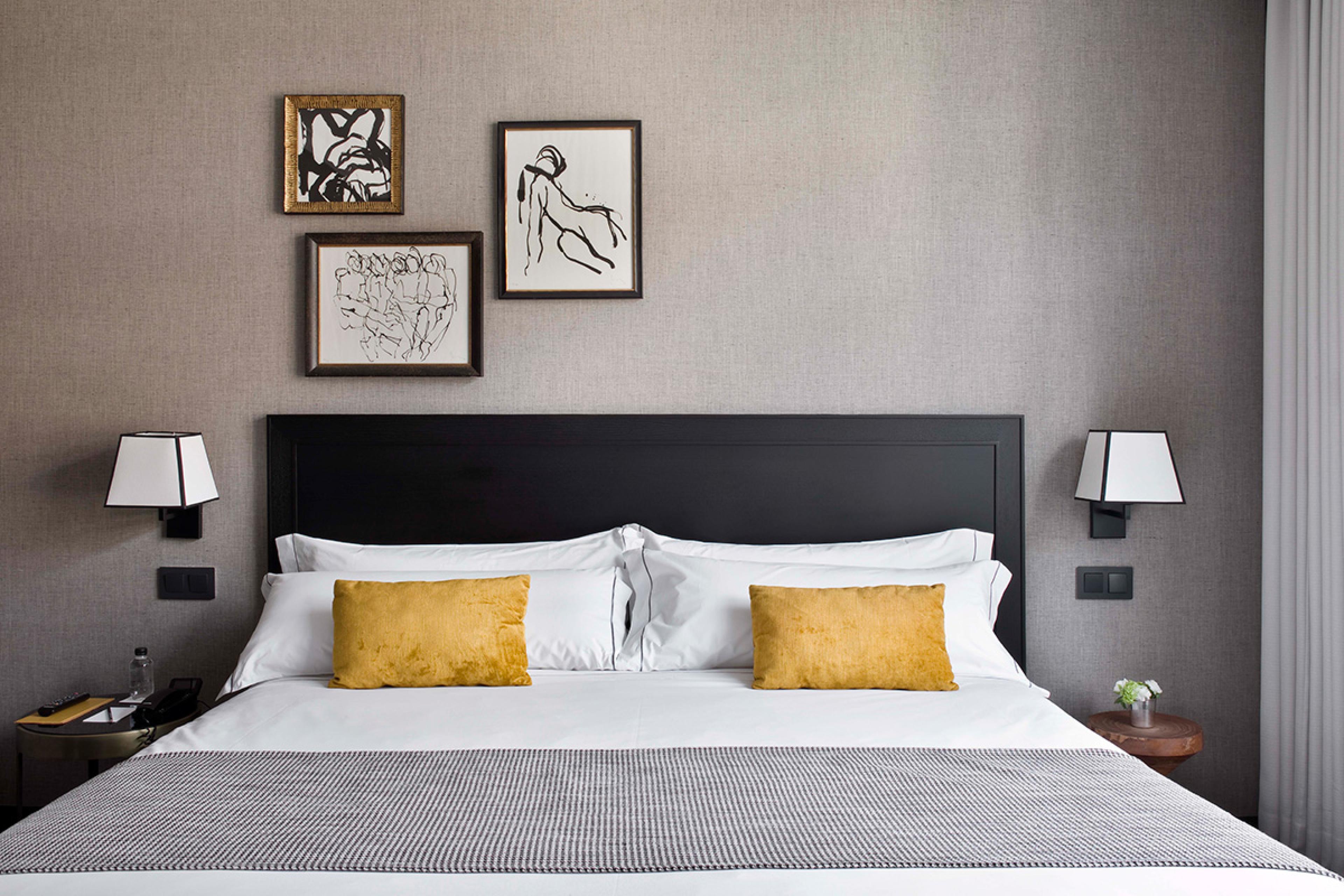 bed with mustard pillows and modern art on the wall