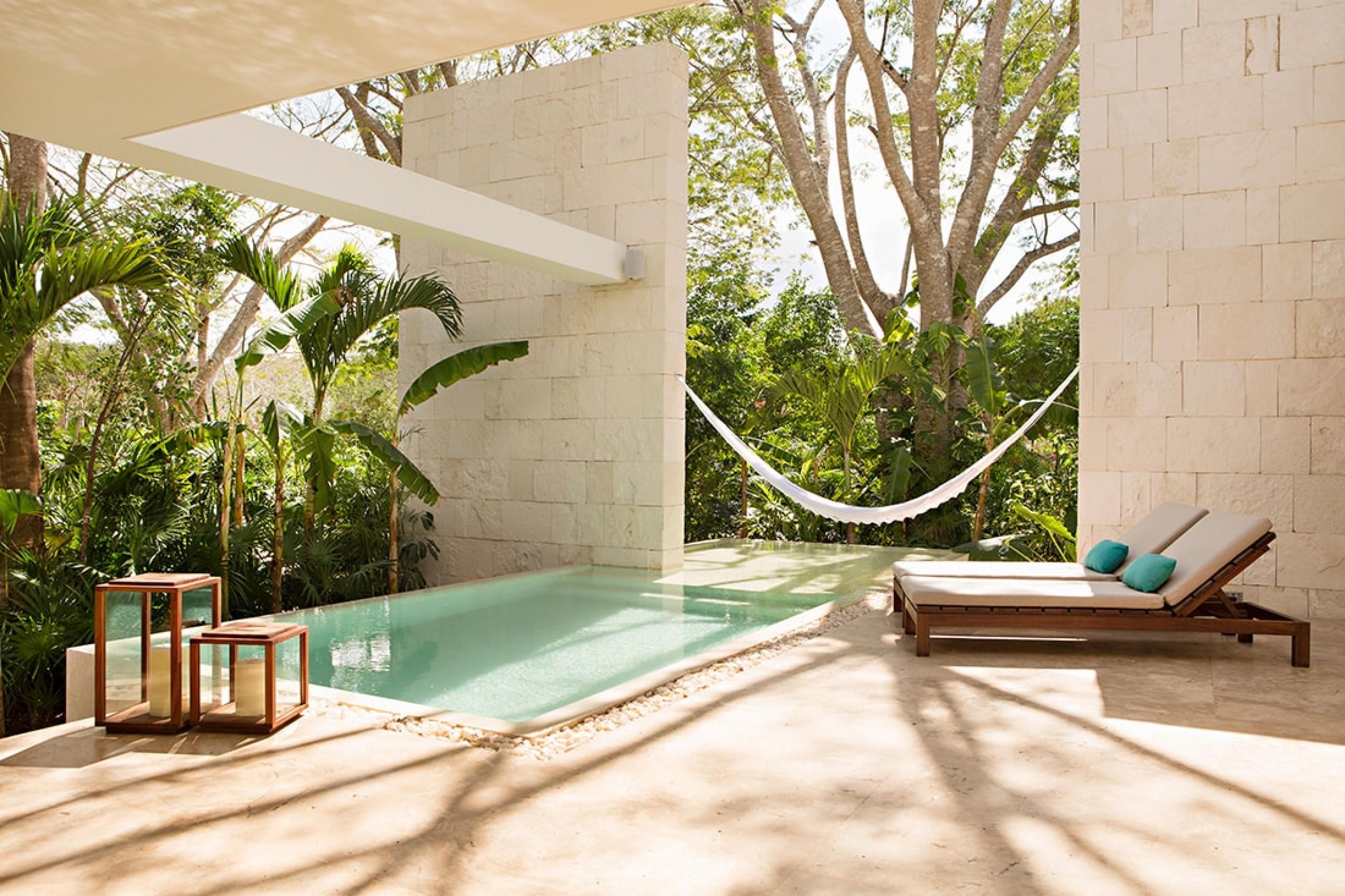 private villa's patio with plunge pool and hammock hanging in front of garden area