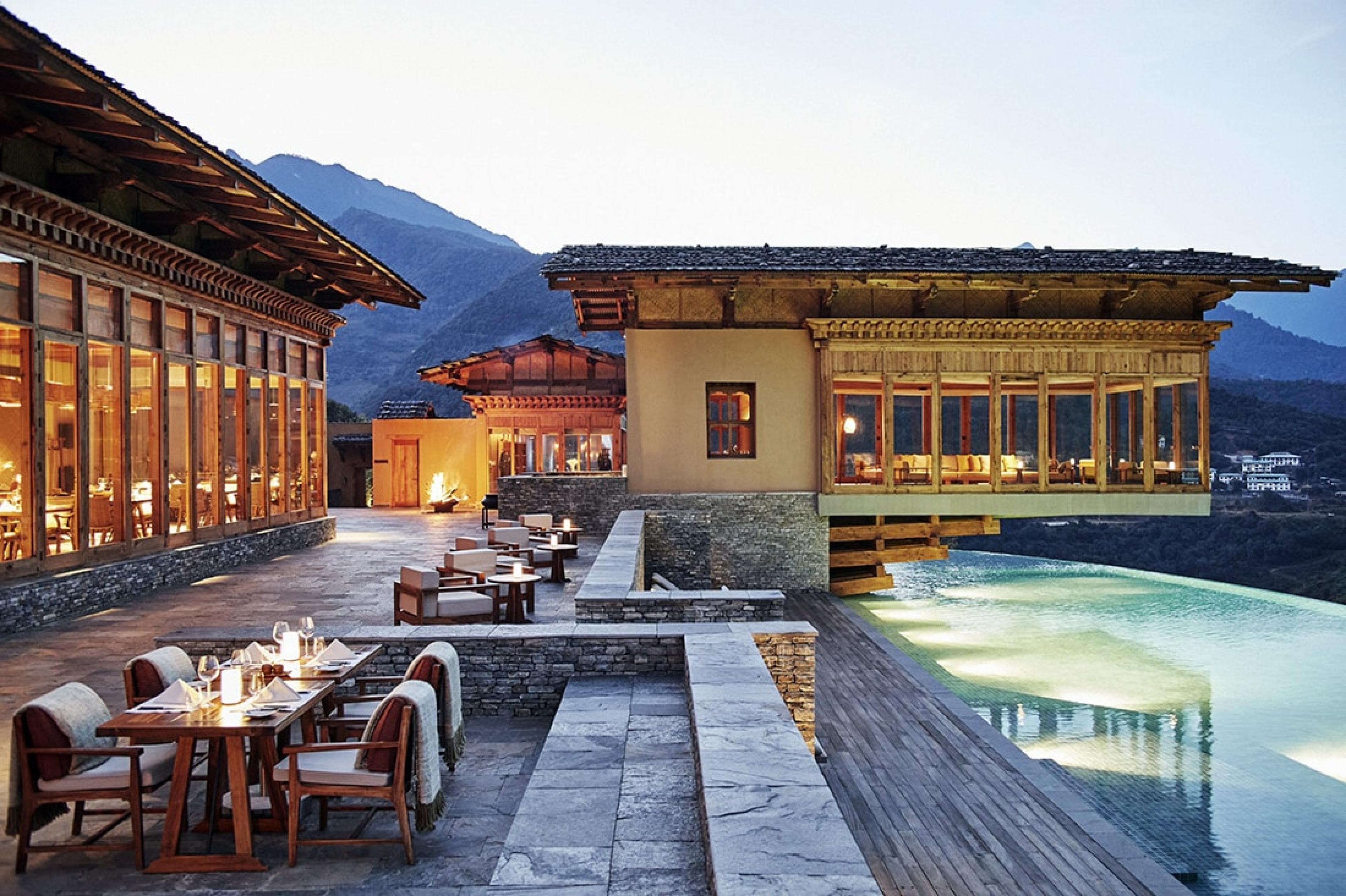 terrace in bhutan with pool and lodge buildings with mountains in background
