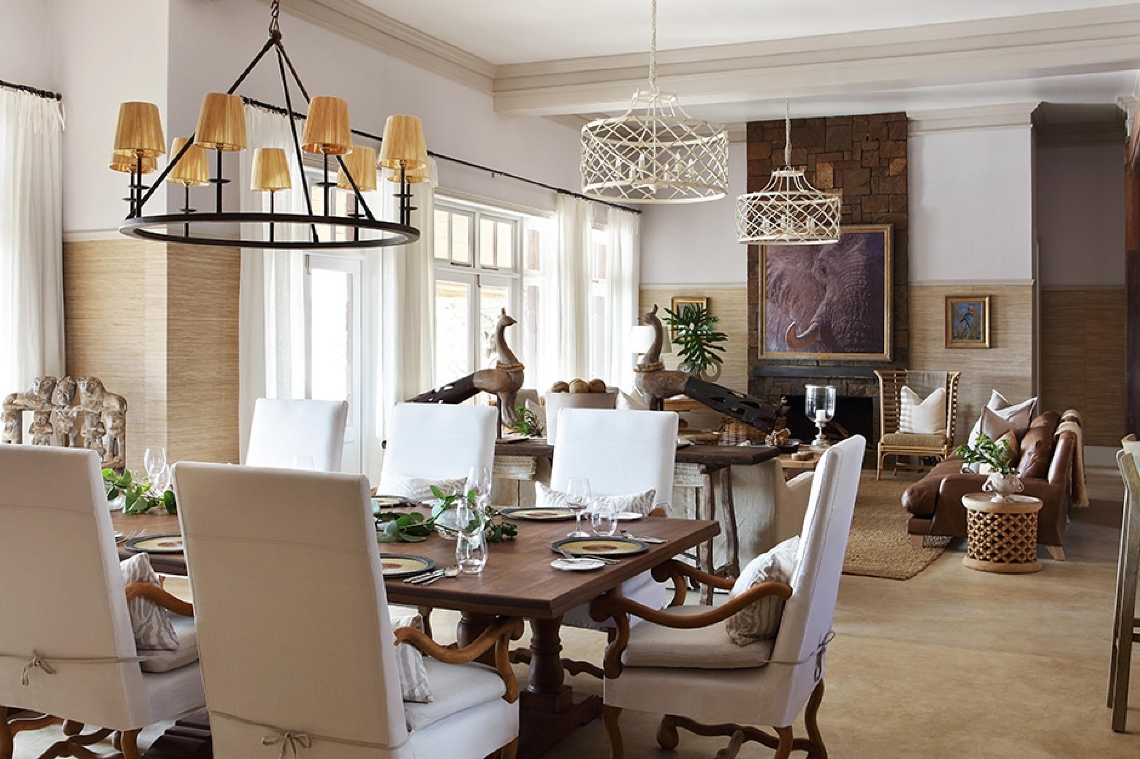 elegant dining room and living area with safari sculpture and paintings