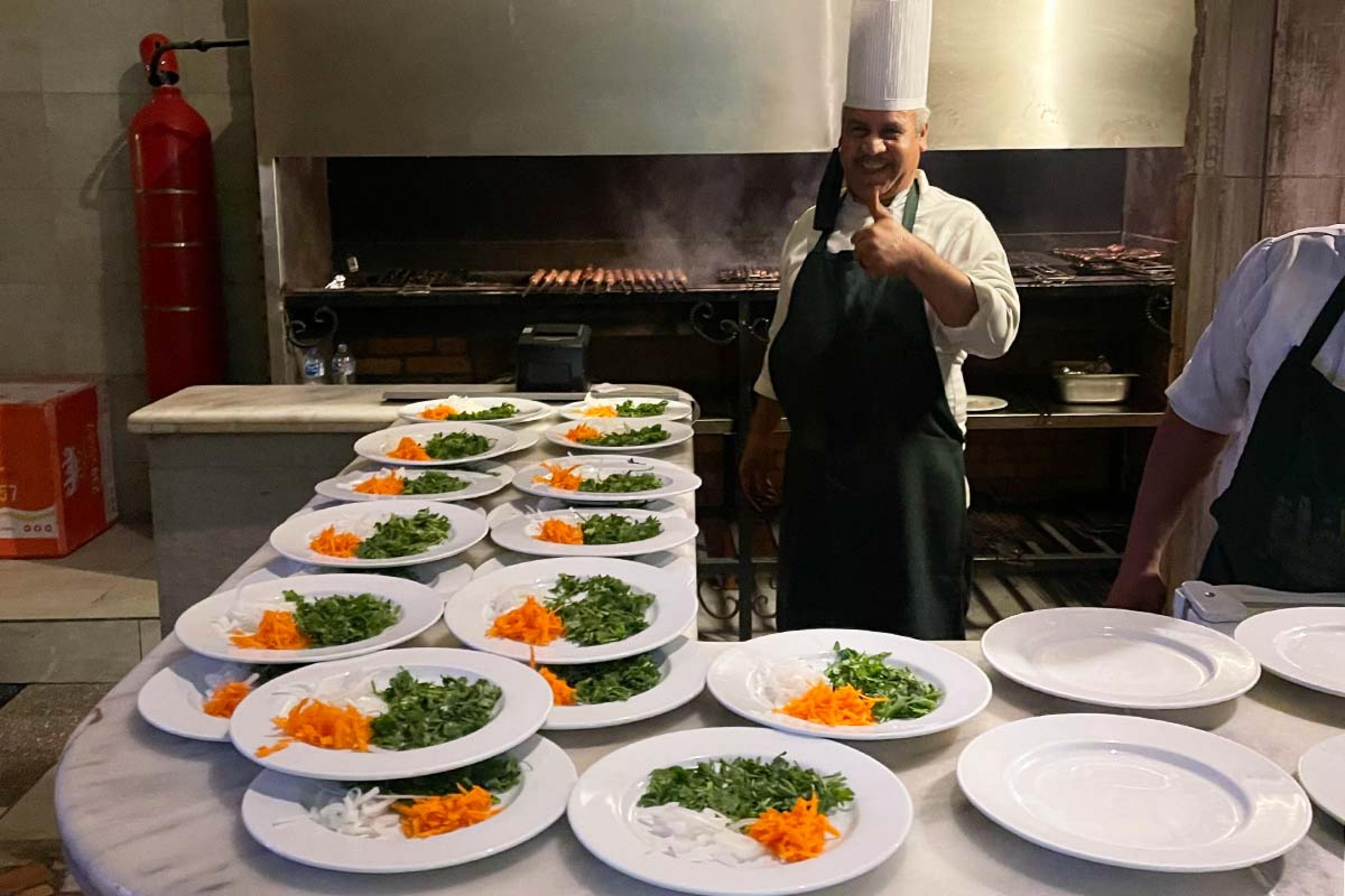 counter with plates of vegetables and a smiling chef