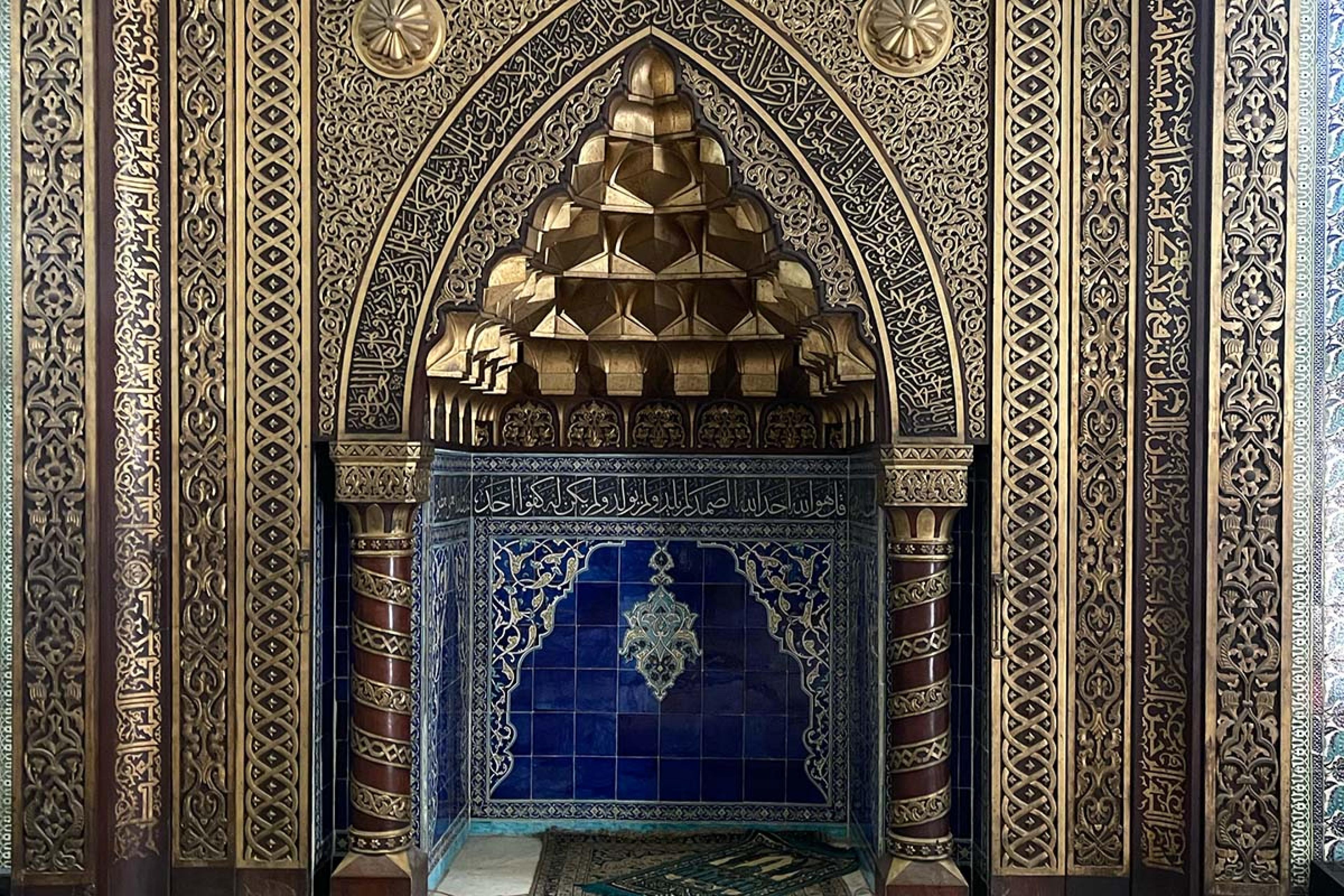 ornate golden pointed archway with blue tiles in the middle