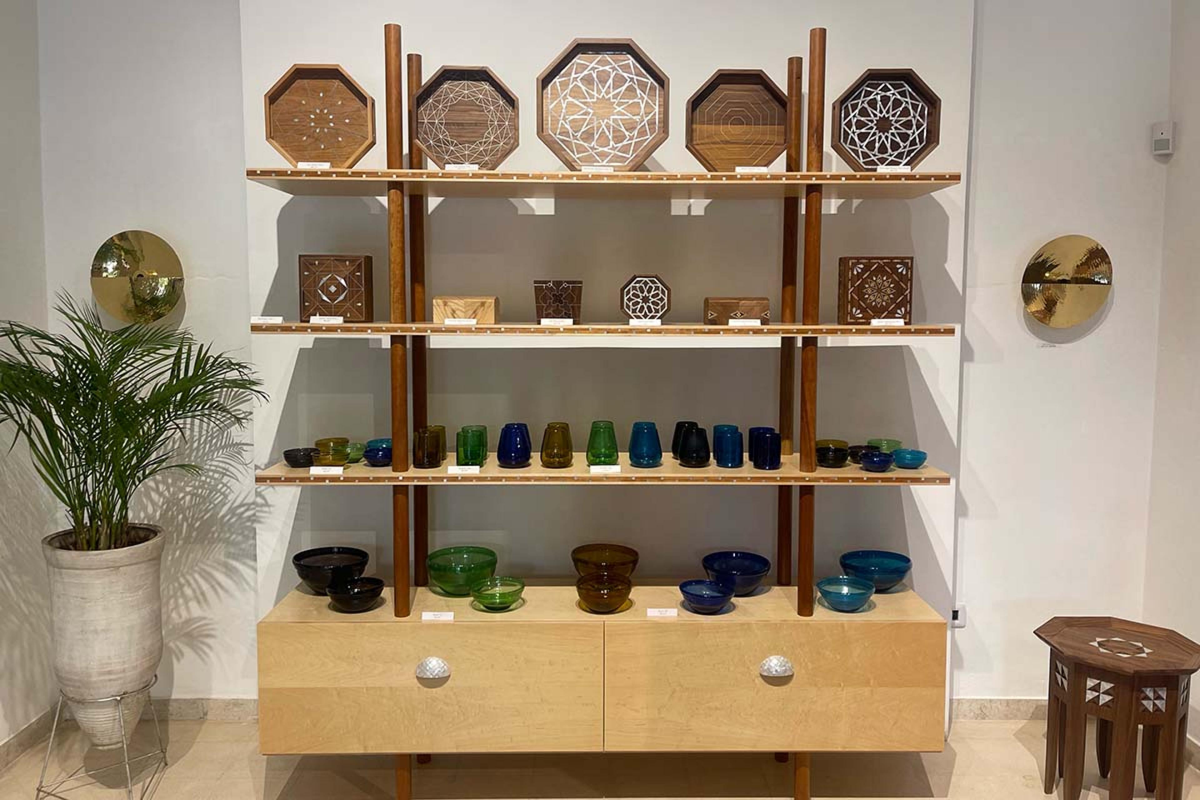 wooden display with colored glassware and wooden geometric dishes