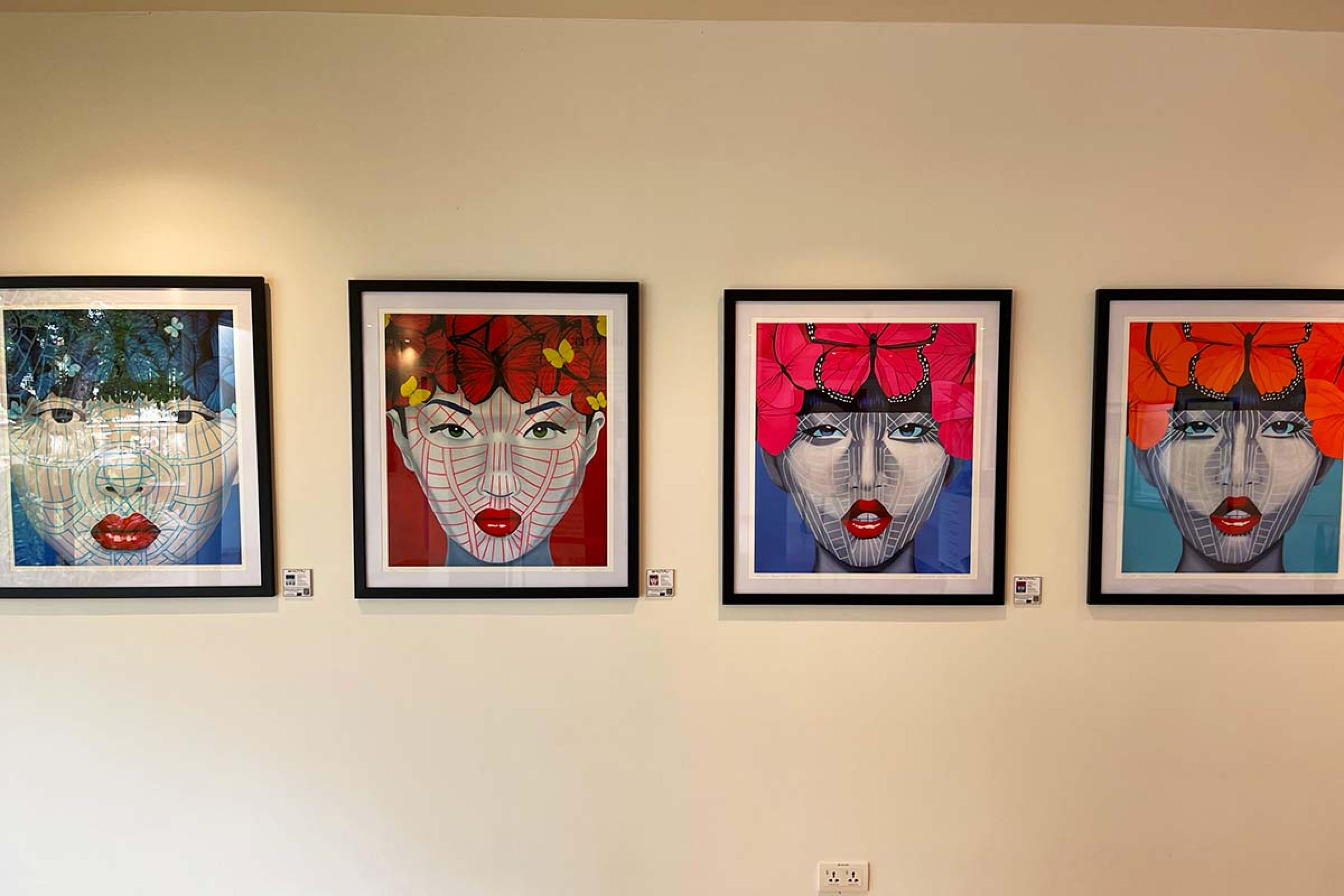 four colorful framed paintings of faces
