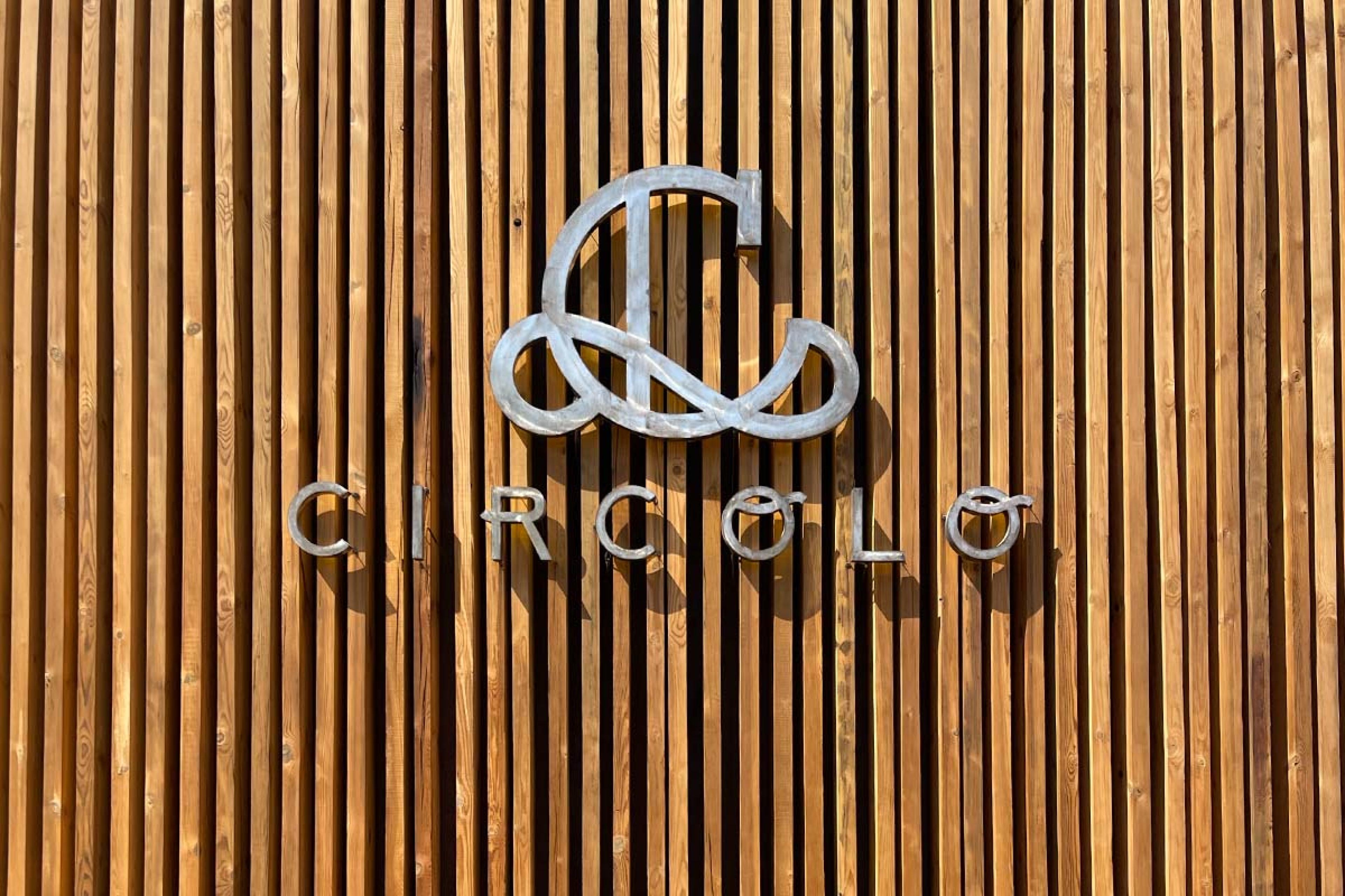 wooden plank sign with metal letters spelling "circolo"