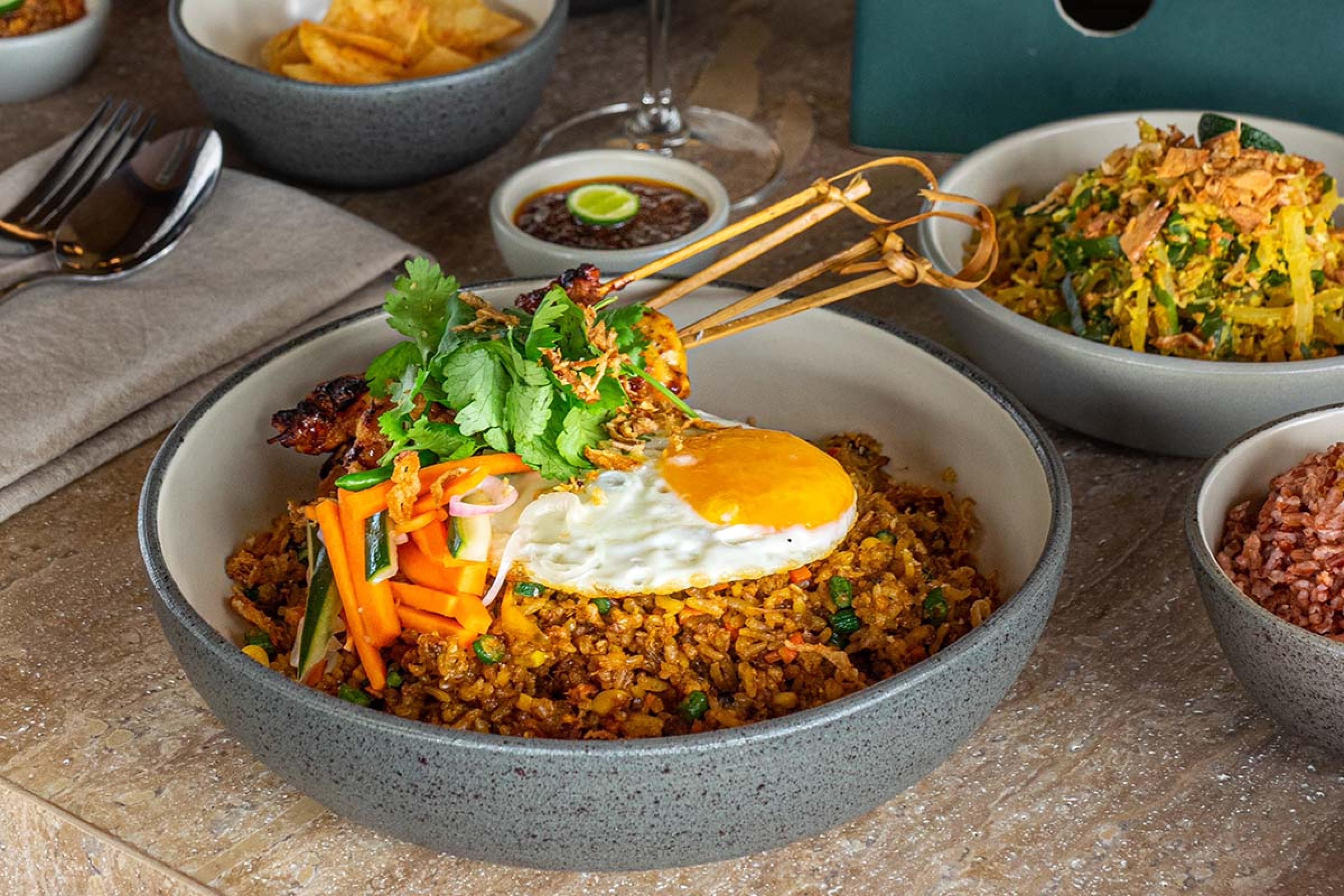 stone bowl with rice, a fried egg and vegetables