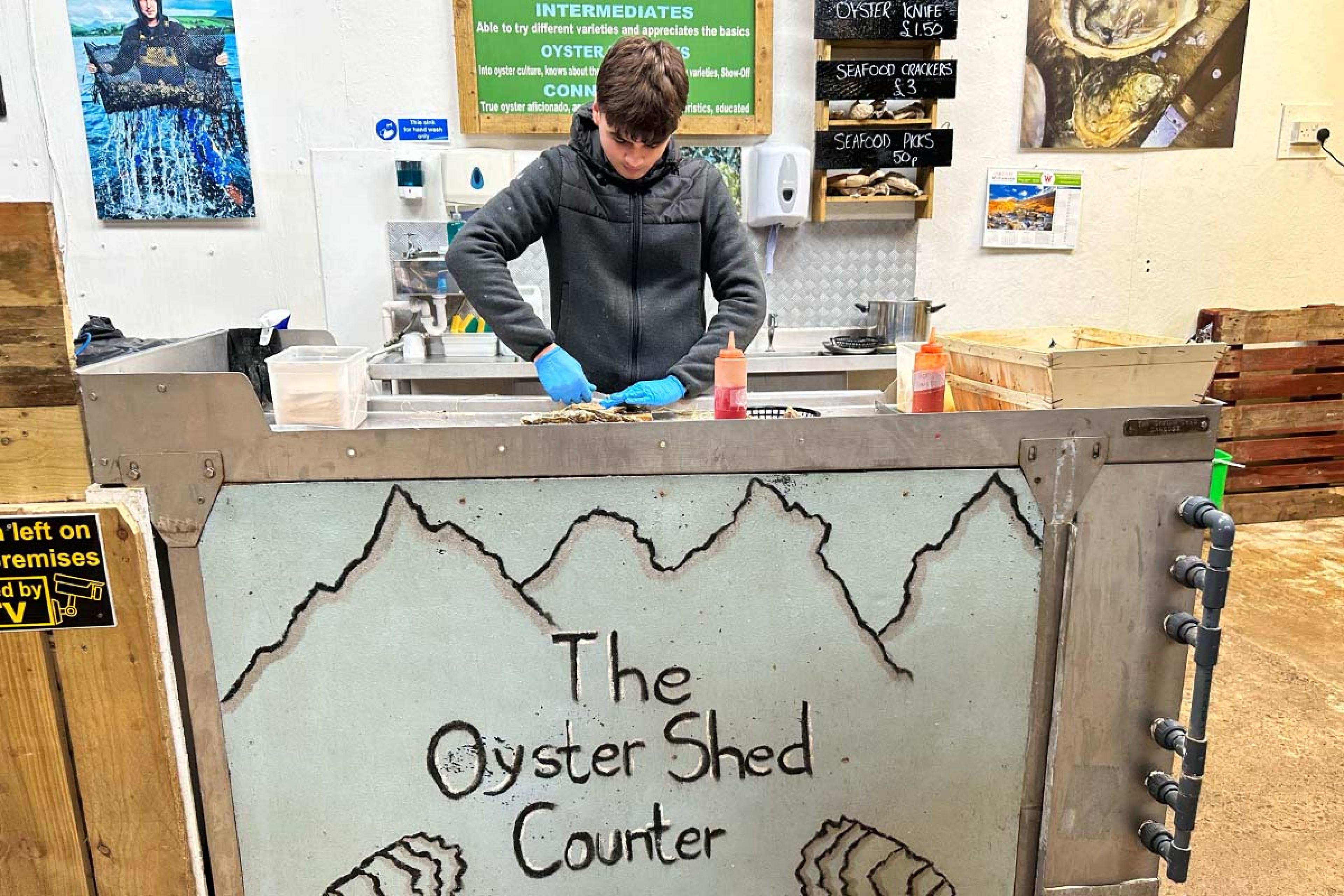 rustic counter with a man preparing seafood behind it