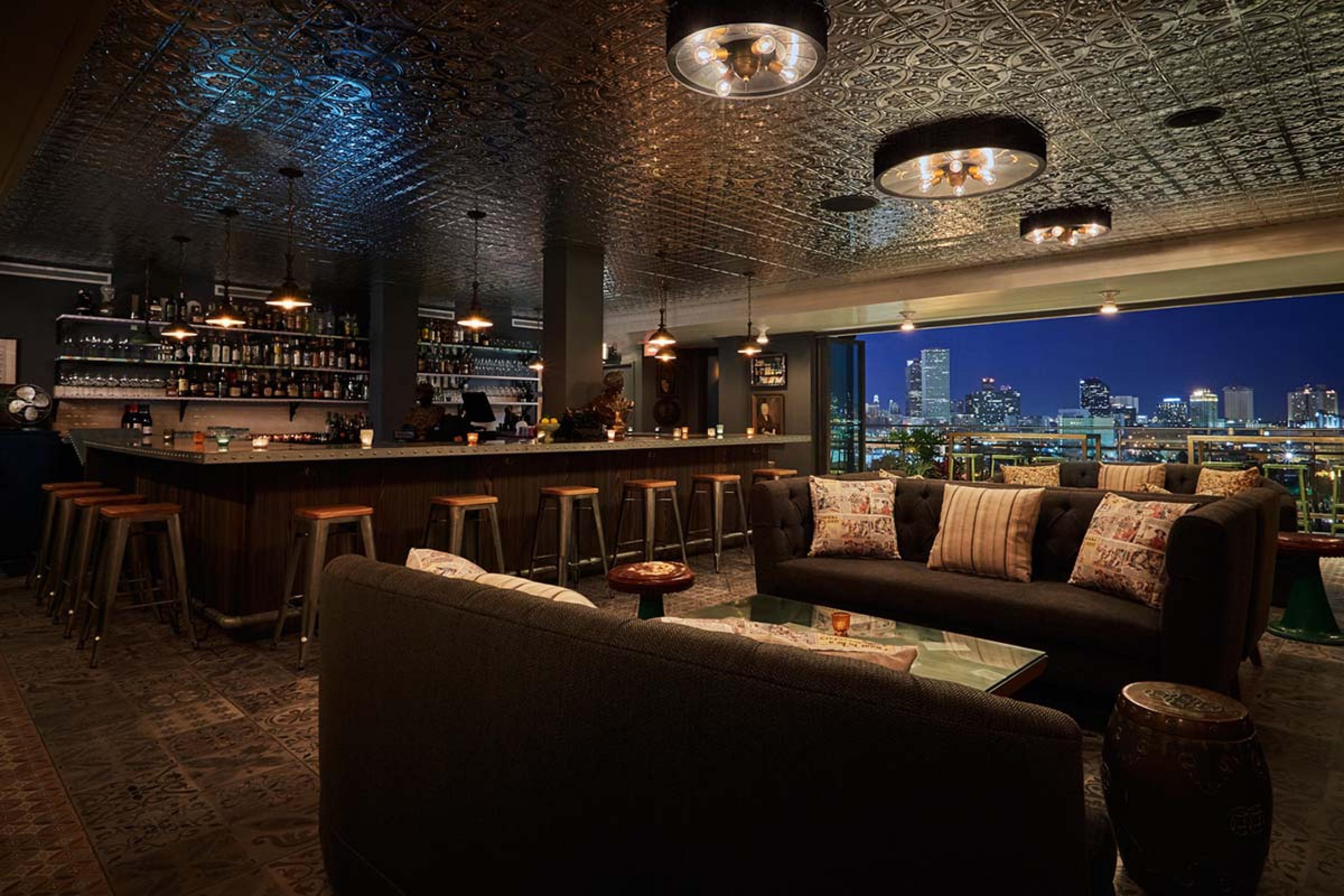 bar with a couch seating area and a reflective ceiling