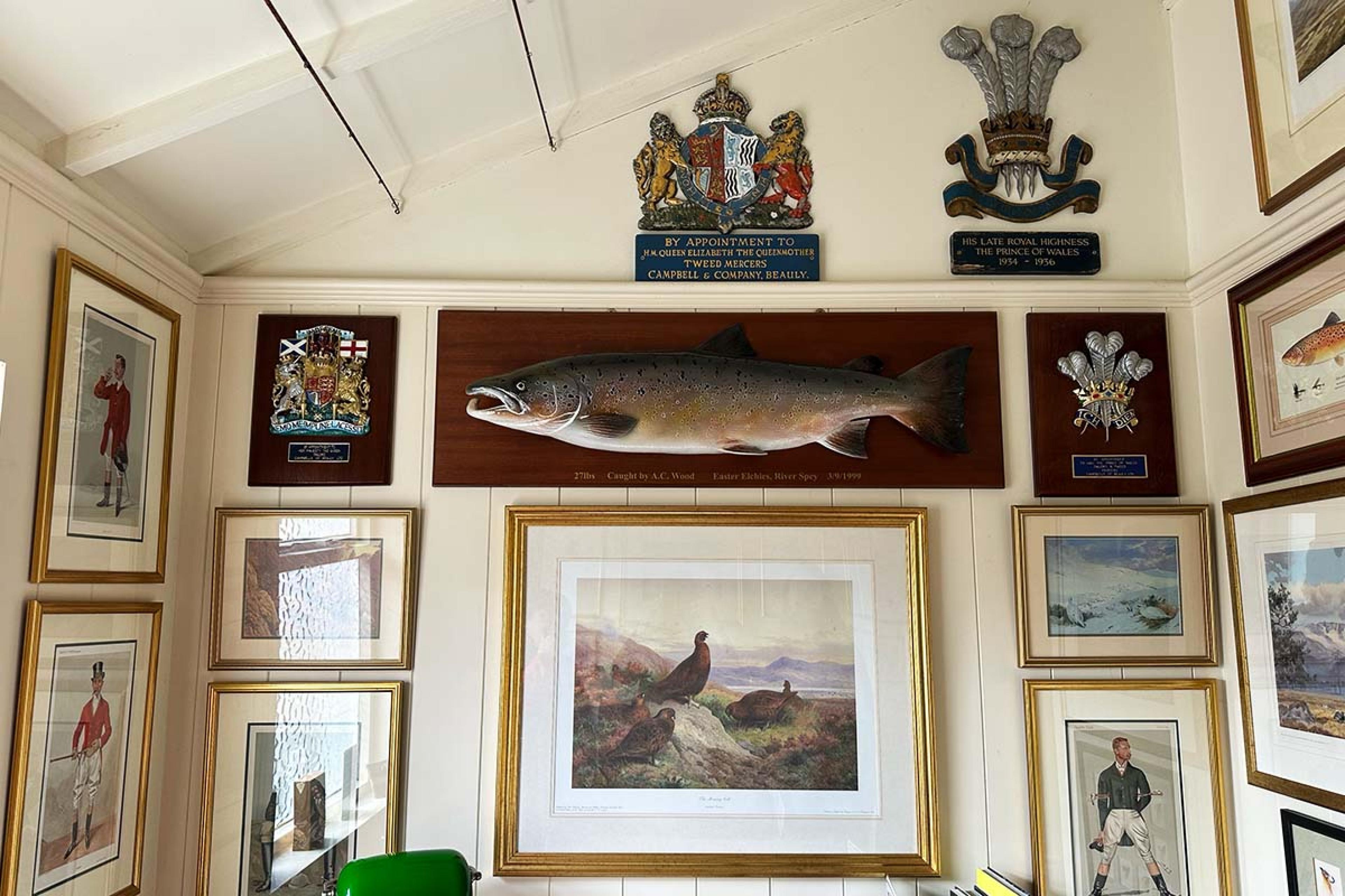 white wall hung with rustic paintings, including a large trout painting