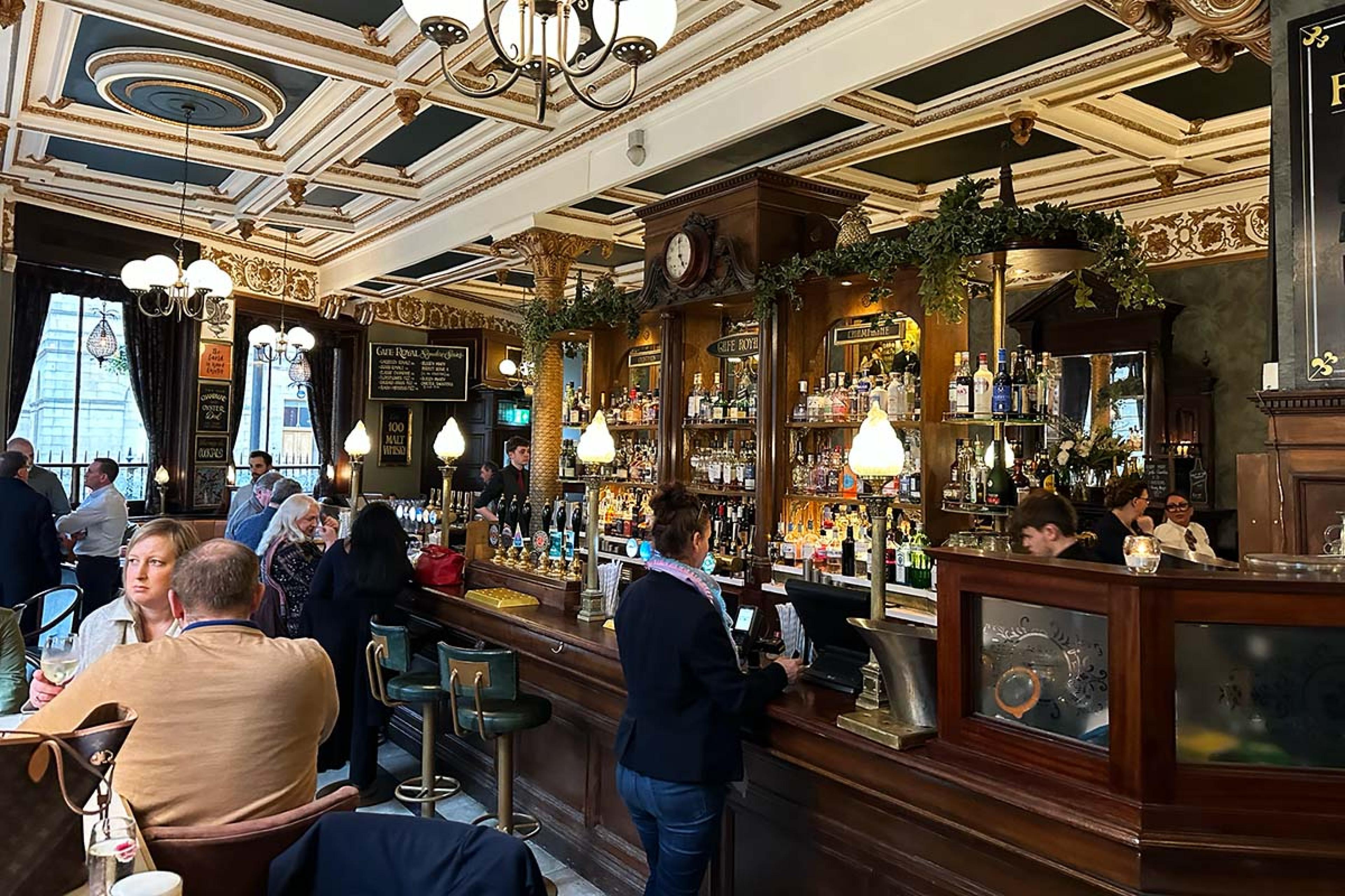 bar and restaurant with a polished wooden bar and an ornate ceiling