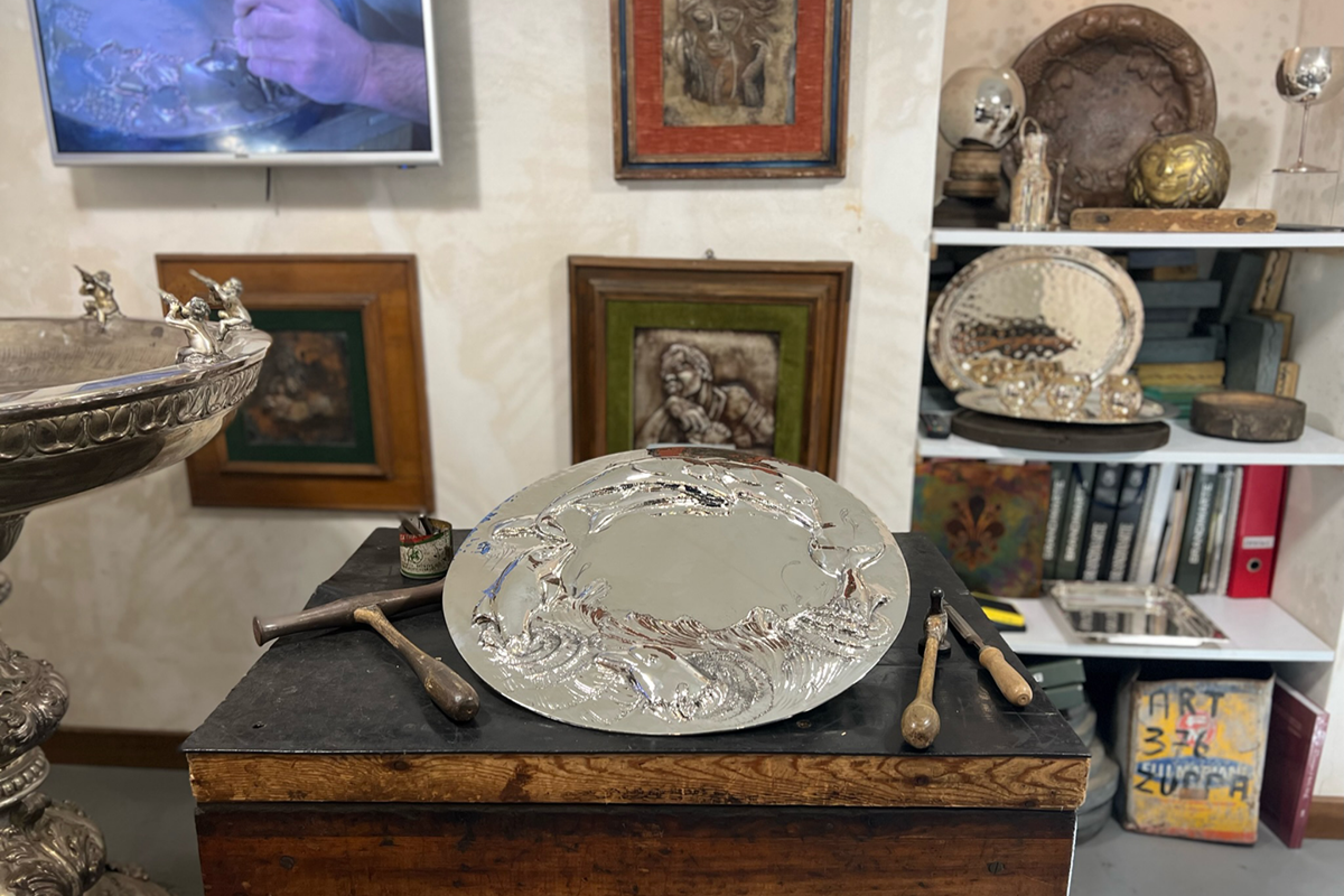 big silver plate with paintings on the wall