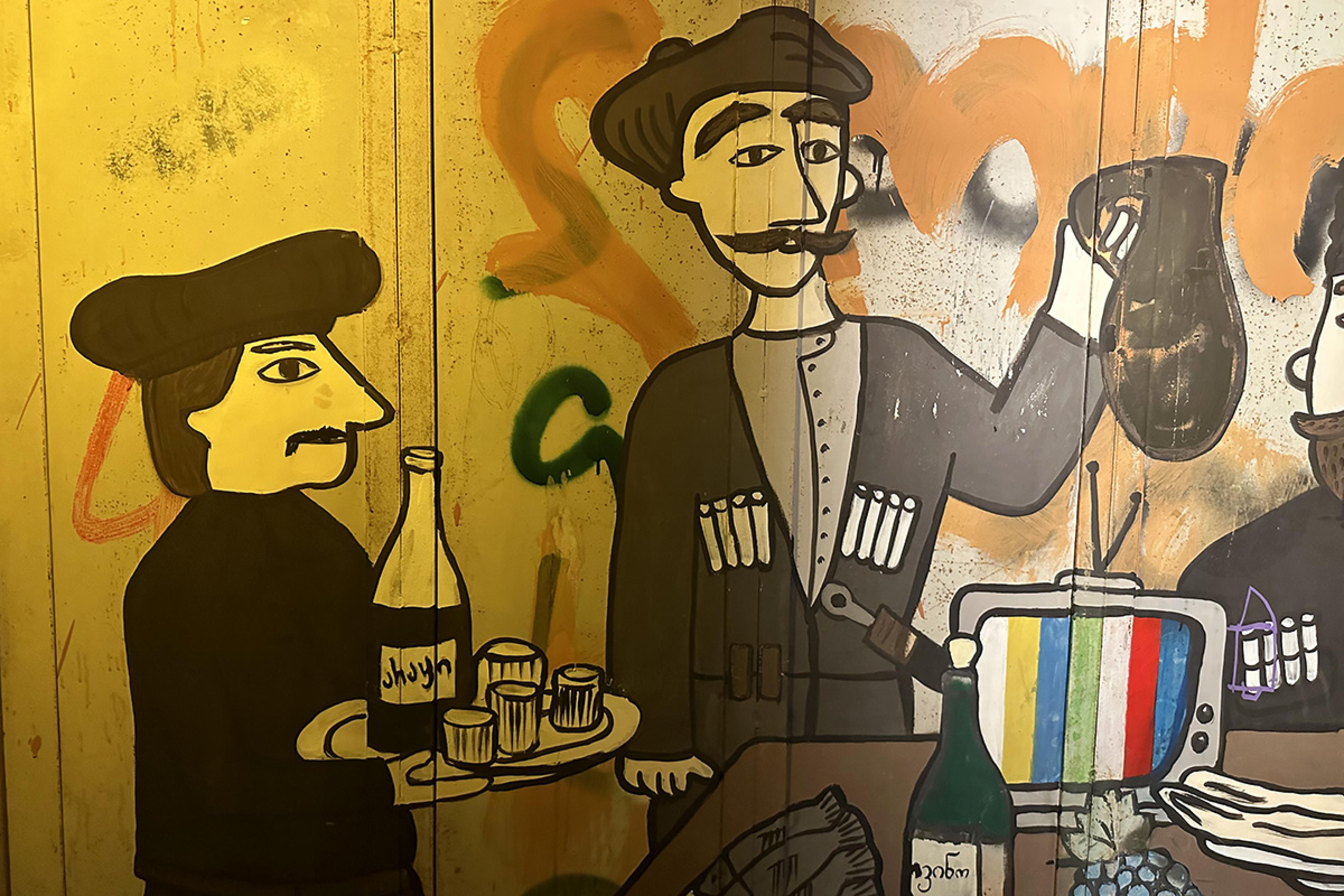 wall painted with two cartoon men serving wine