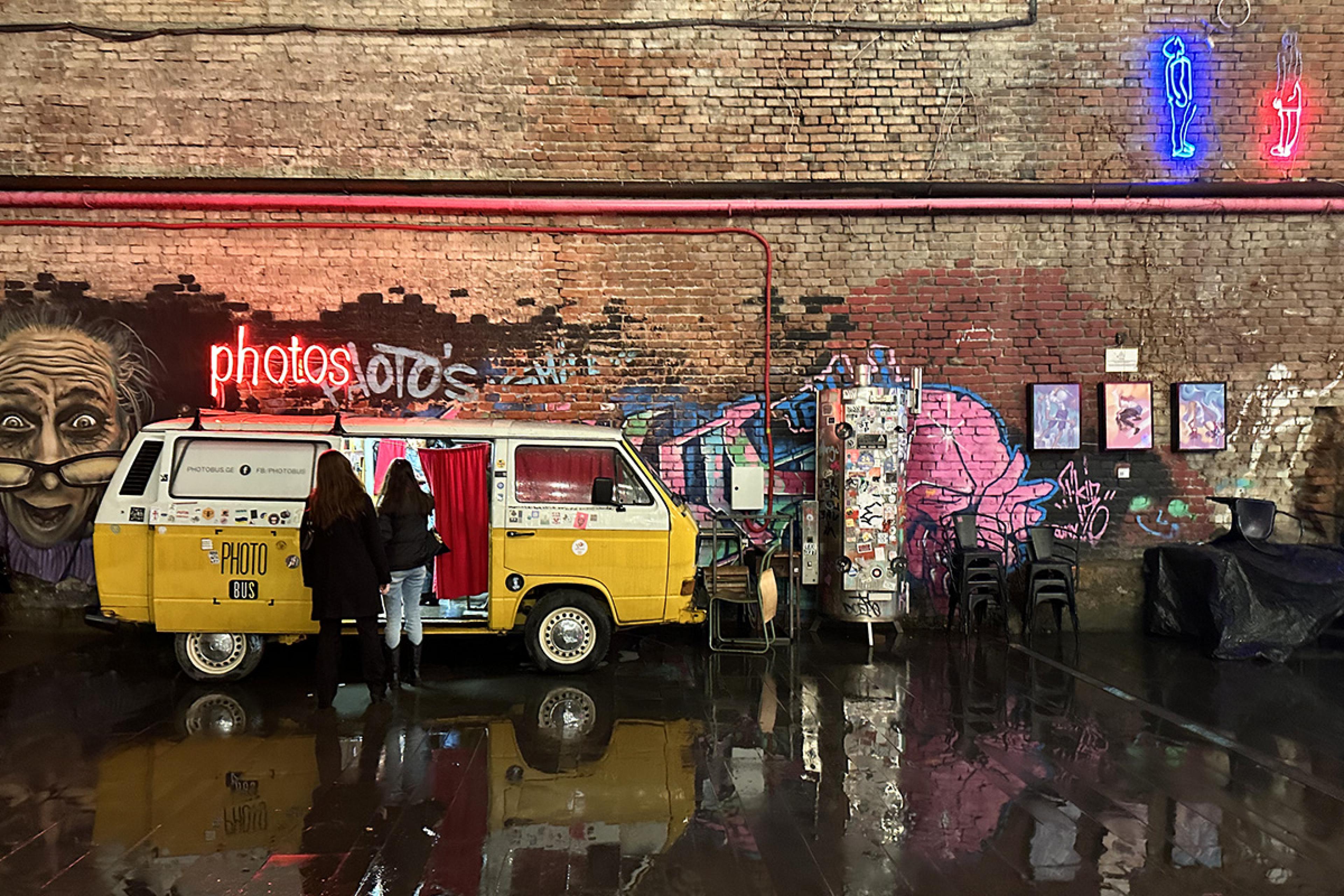 yellow van outside a painted brick wall