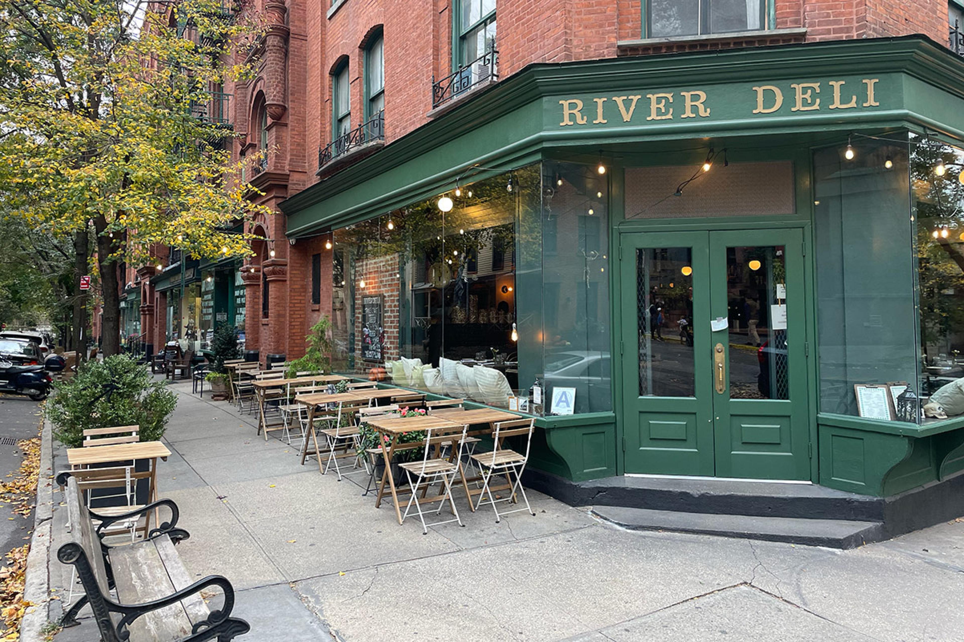 corner restaurant with green paint and red brick with sign saying river deli