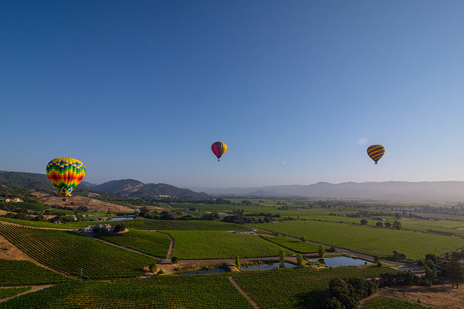 3 hot-air balloons in the sky over Napa Valley California