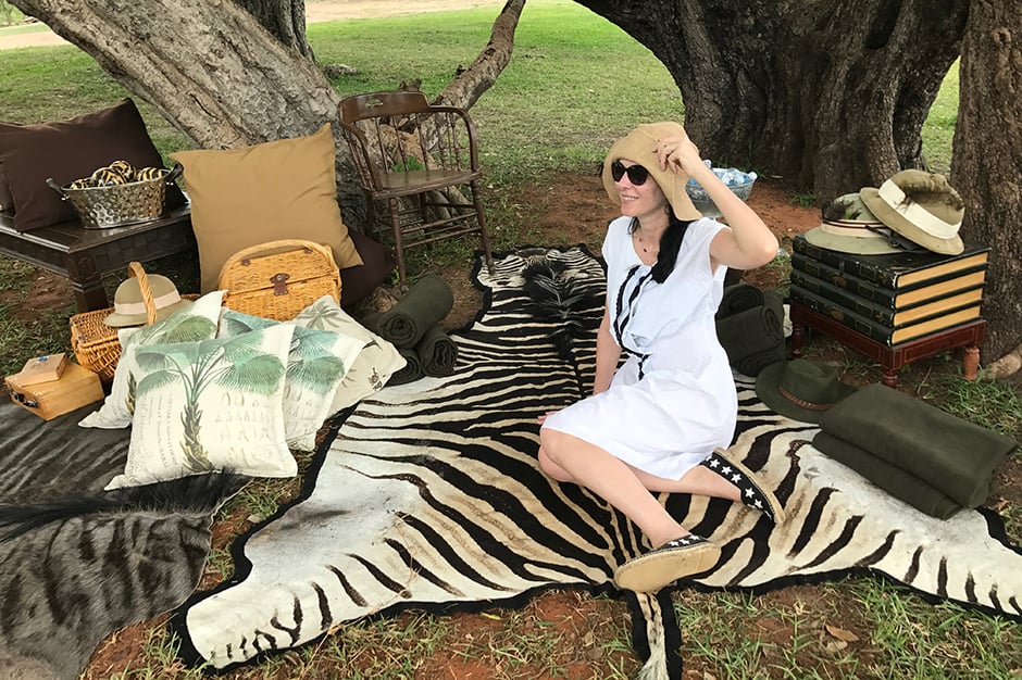 Jill Kargman sitting outdoor on zebra skin while on safari in Africa
