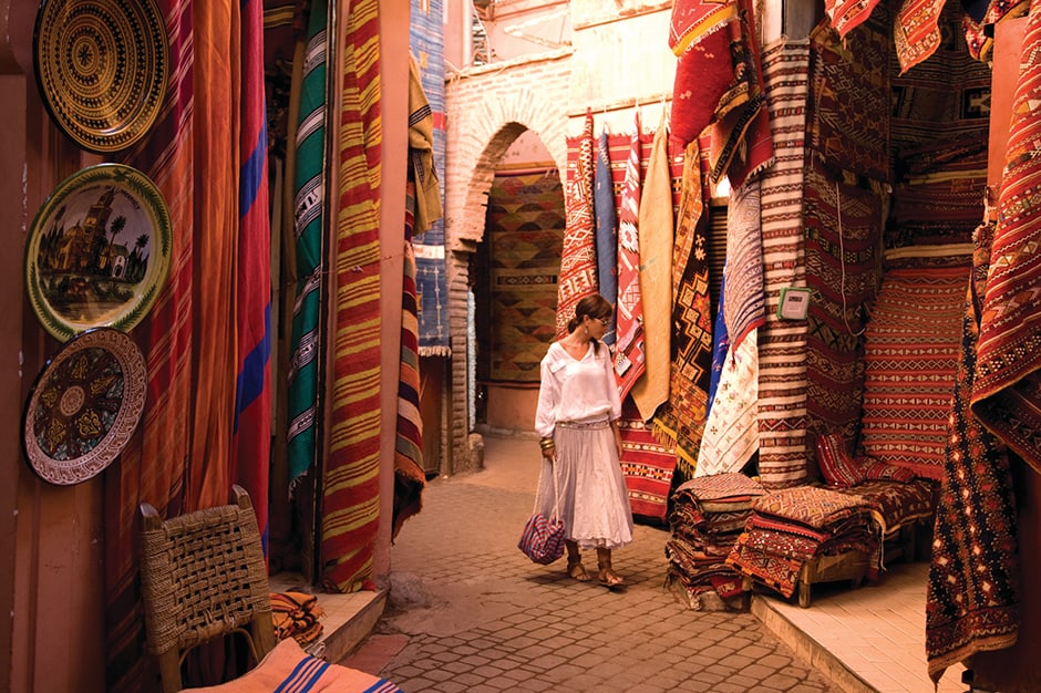 Woman shopping among textiles in a souk in Marrakech