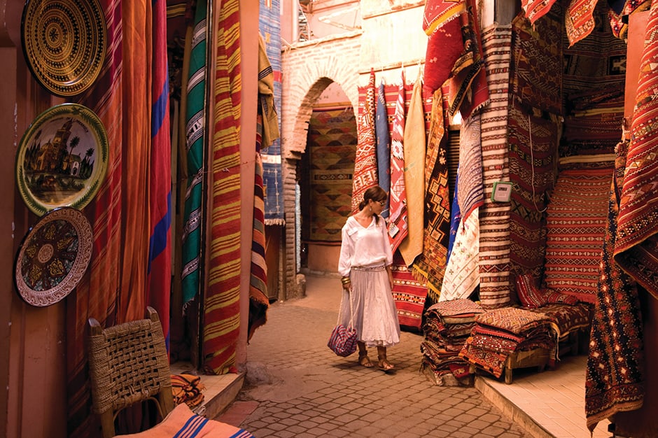 Woman looking at rugs in a Marrakech souk