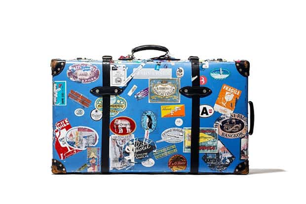 Blue suitcase covered with travel decals