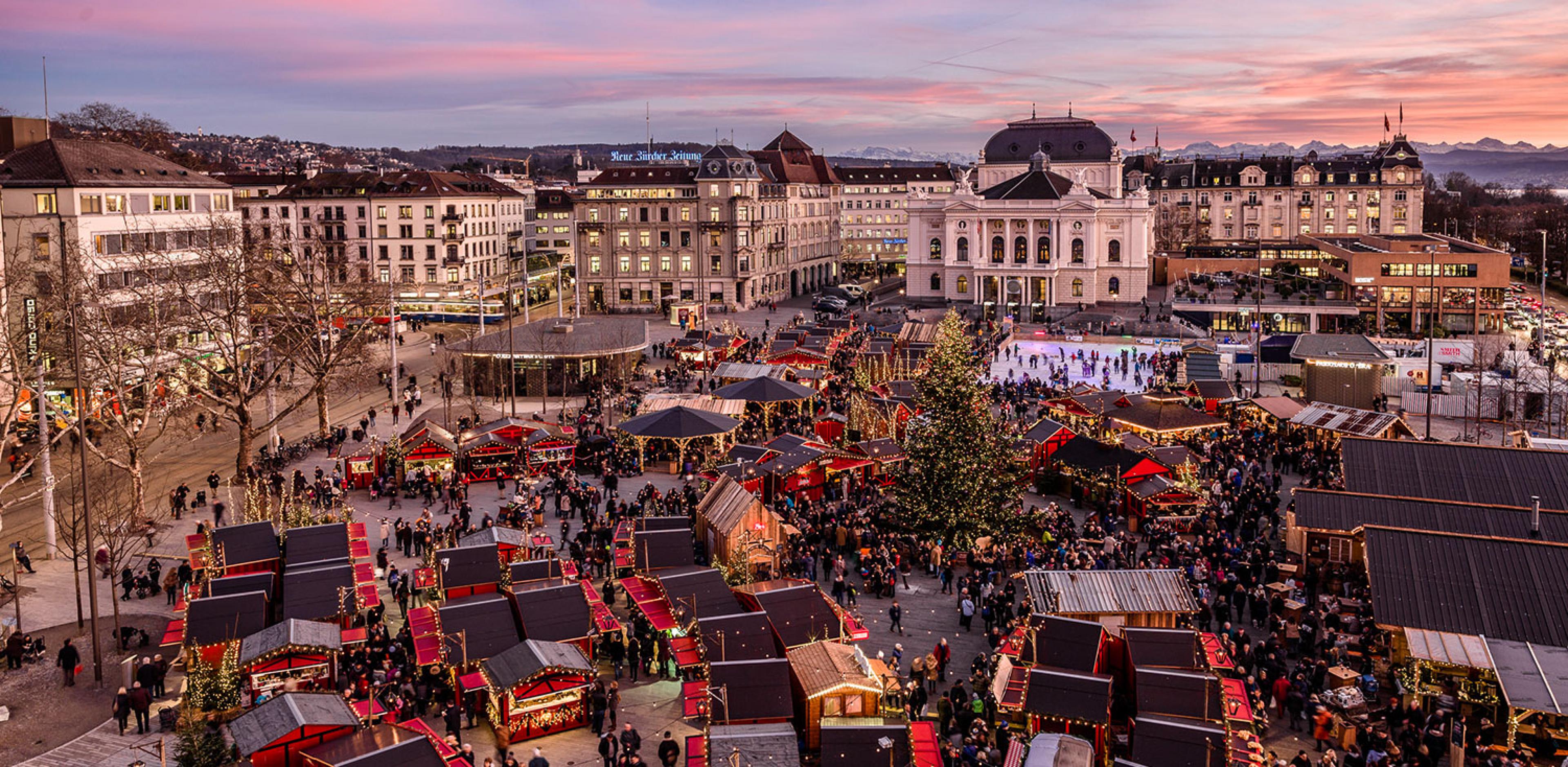 aerial view of zurich christmas market with opera house and alps in background
