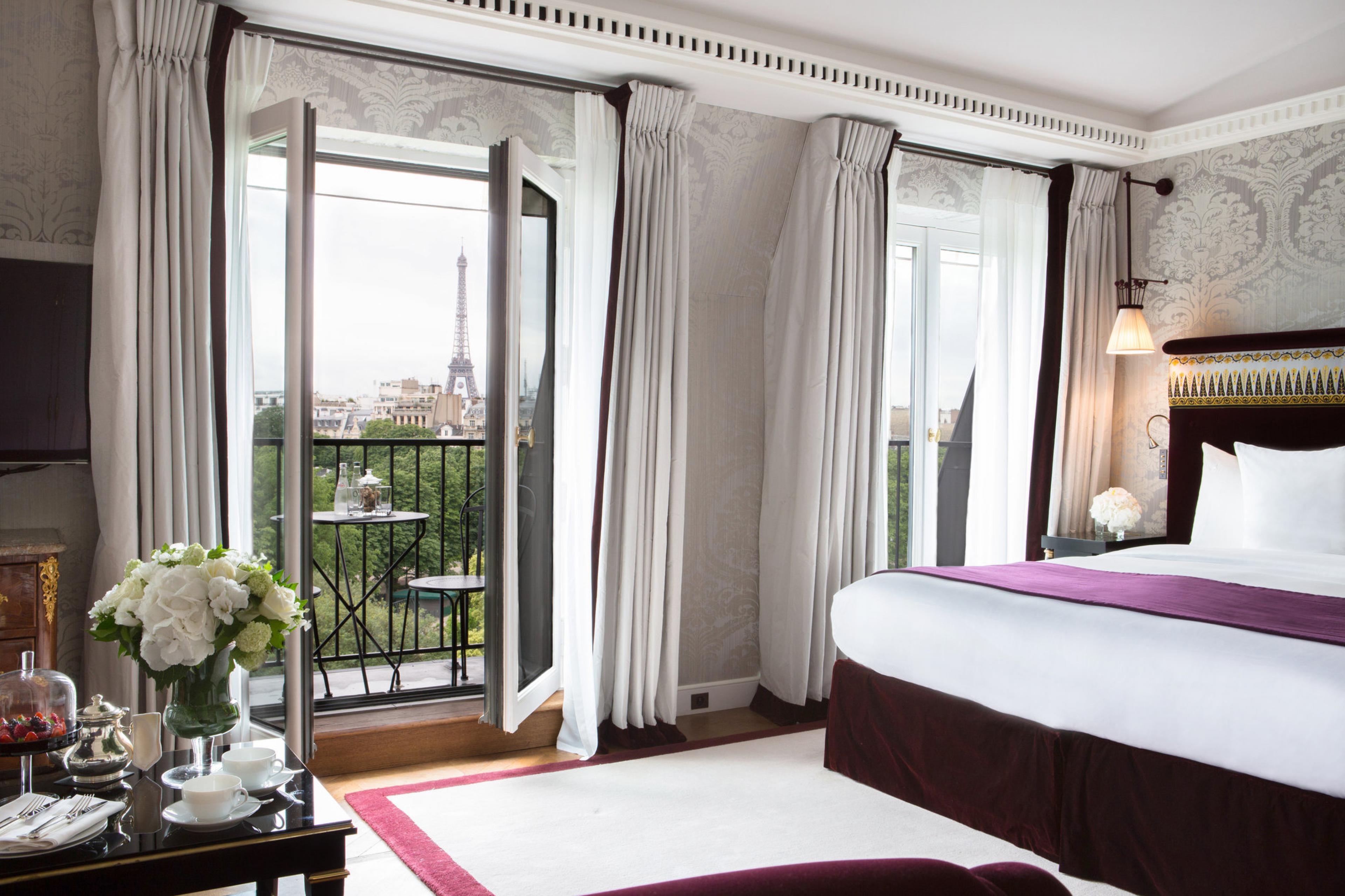 hotel room with french doors opening to view of eiffel tower