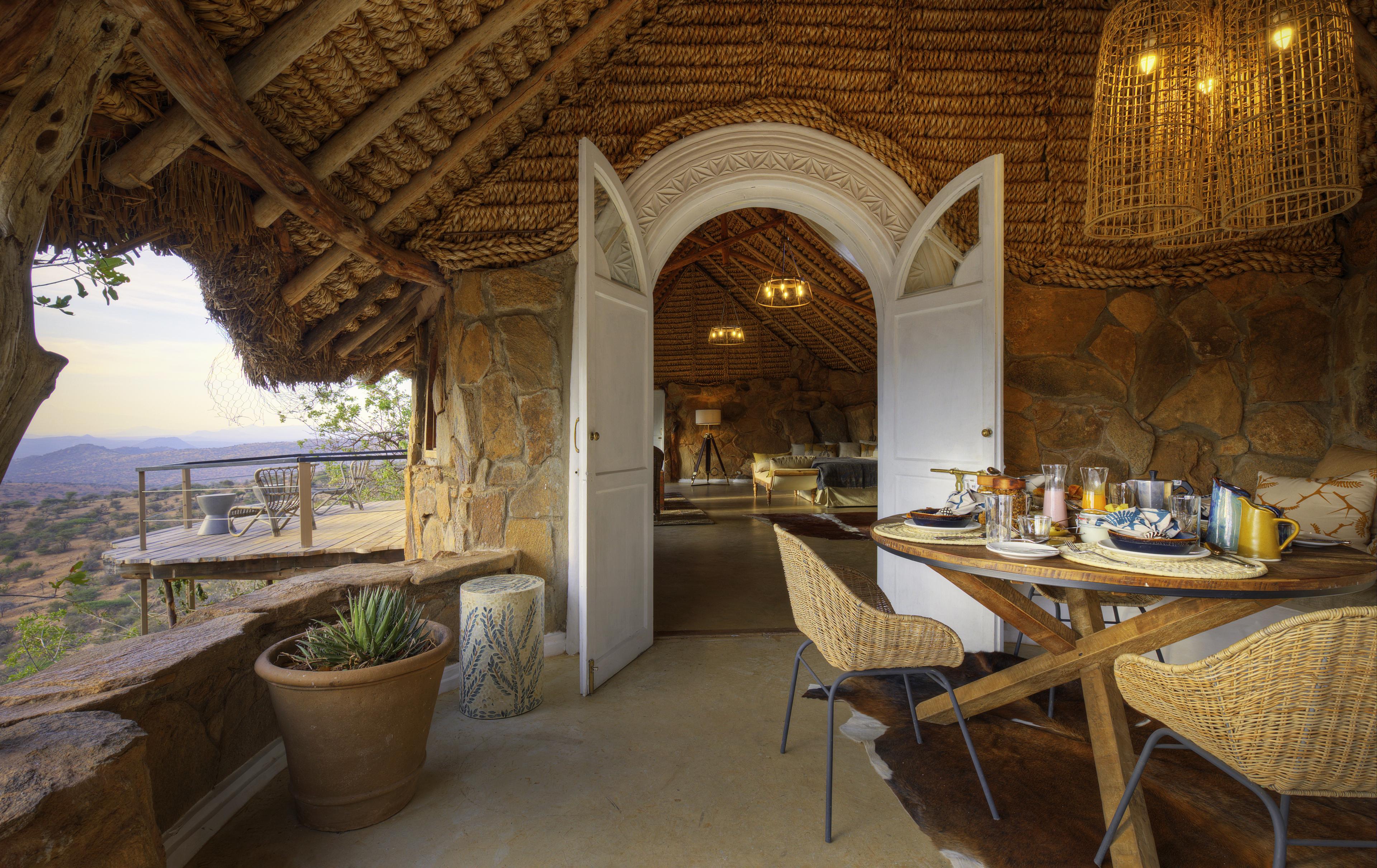 safari lodge terrace with white doors and open air view out to rolling landscape