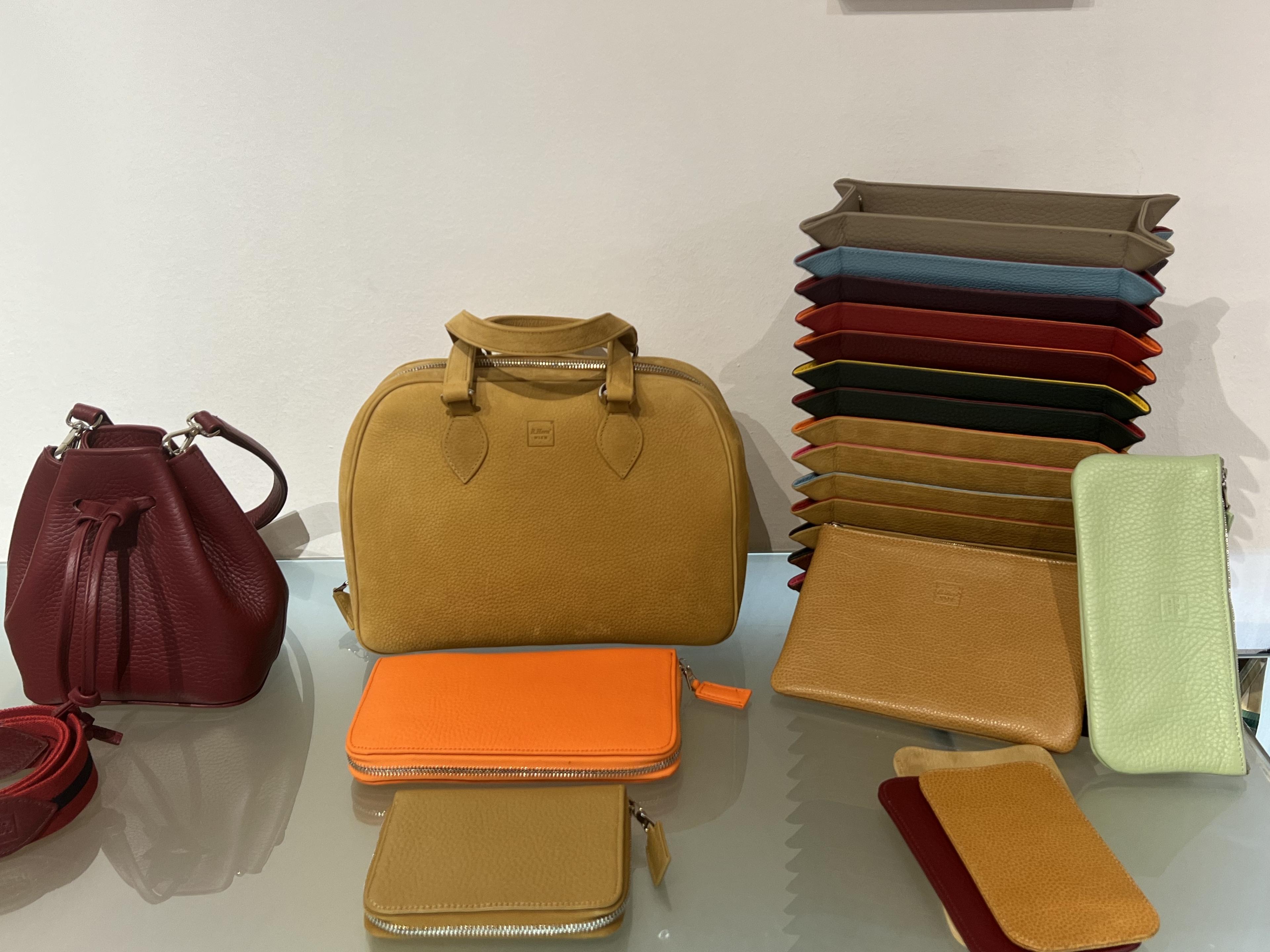 leather trays and clutch purses in multiple colors in a store