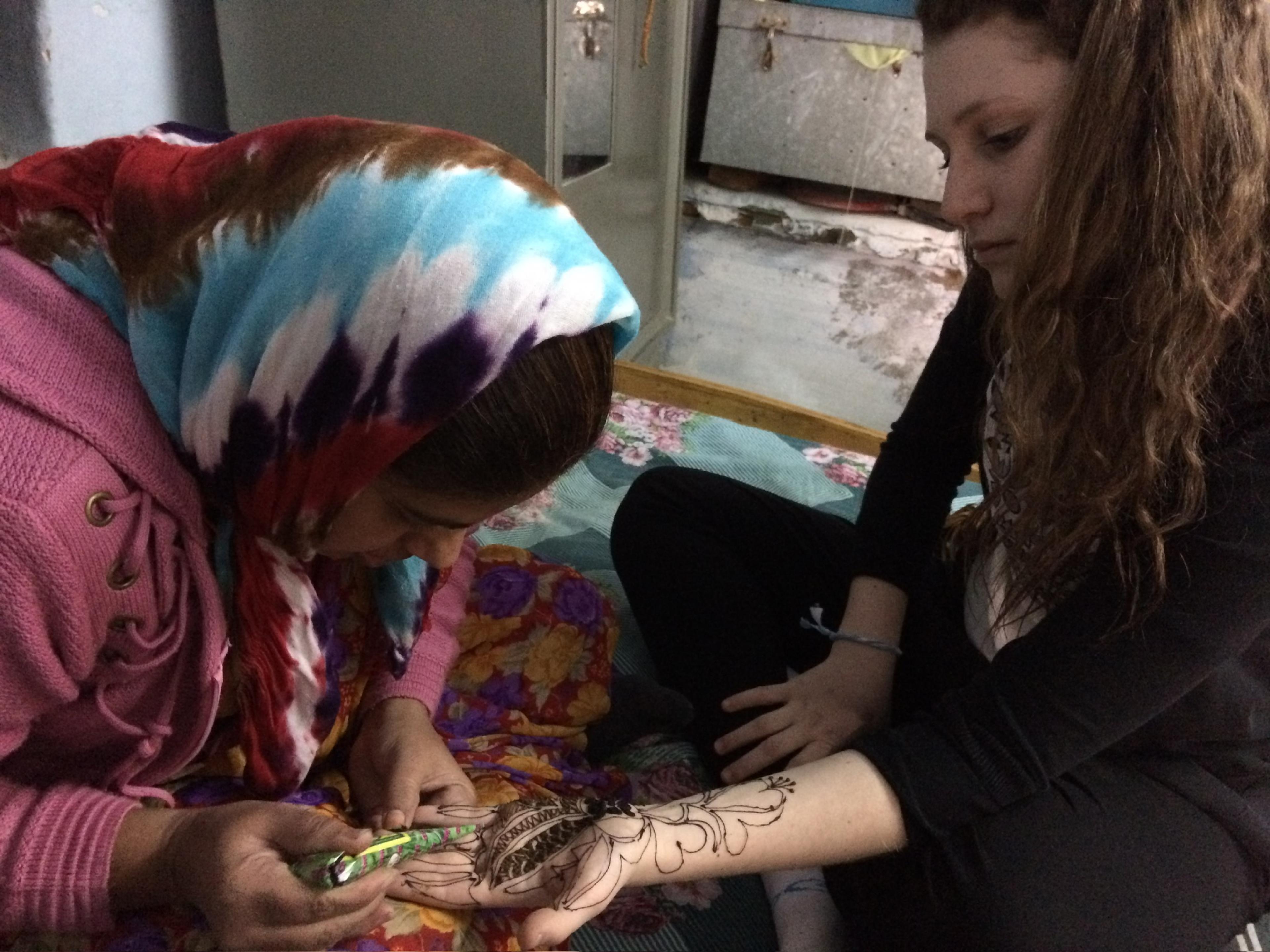 Woman getting henna on her hand