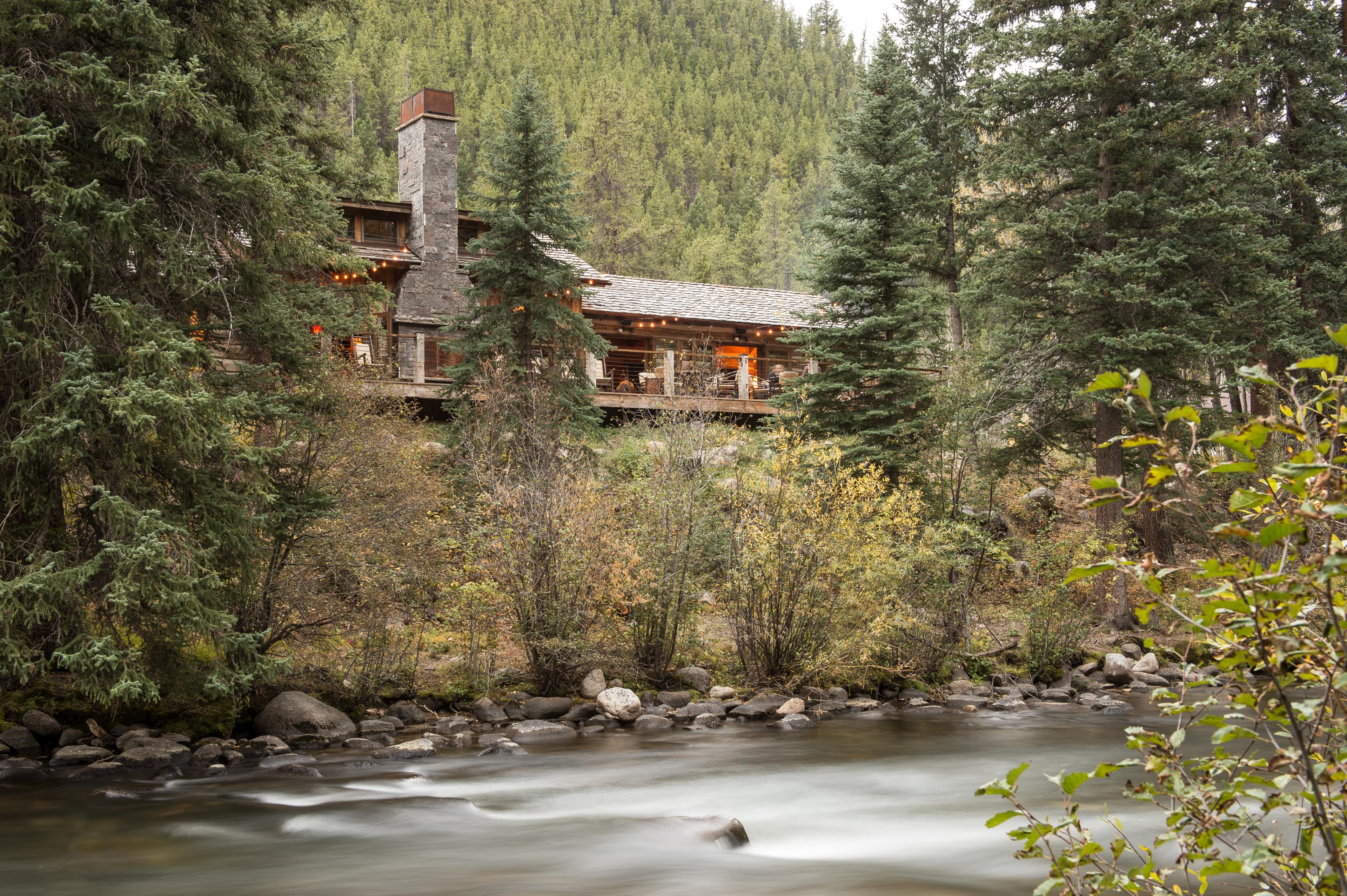 log cabin perched above a river
