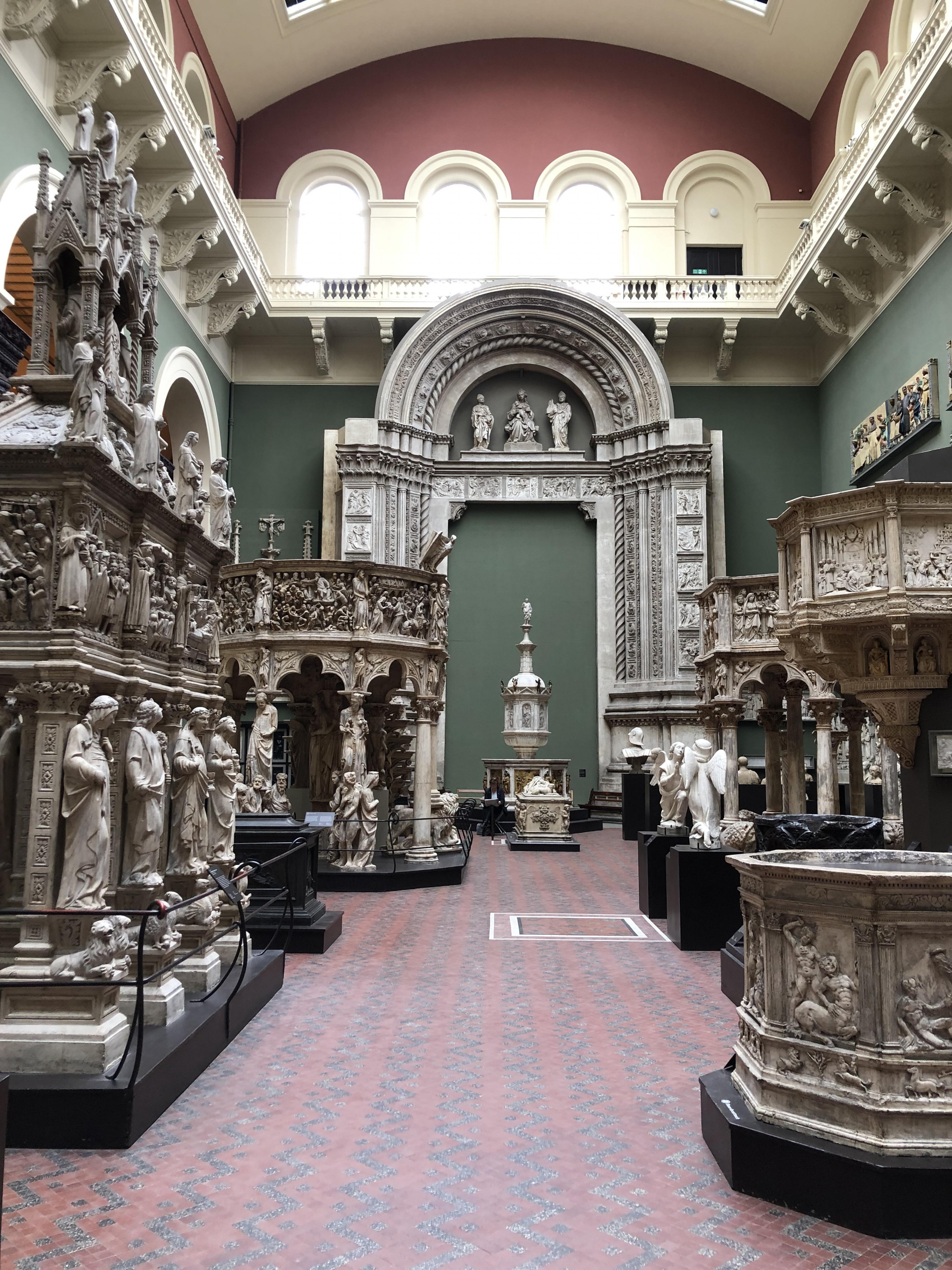 inside a historic museum in london with high ceilings and Gothic church sculptures on display