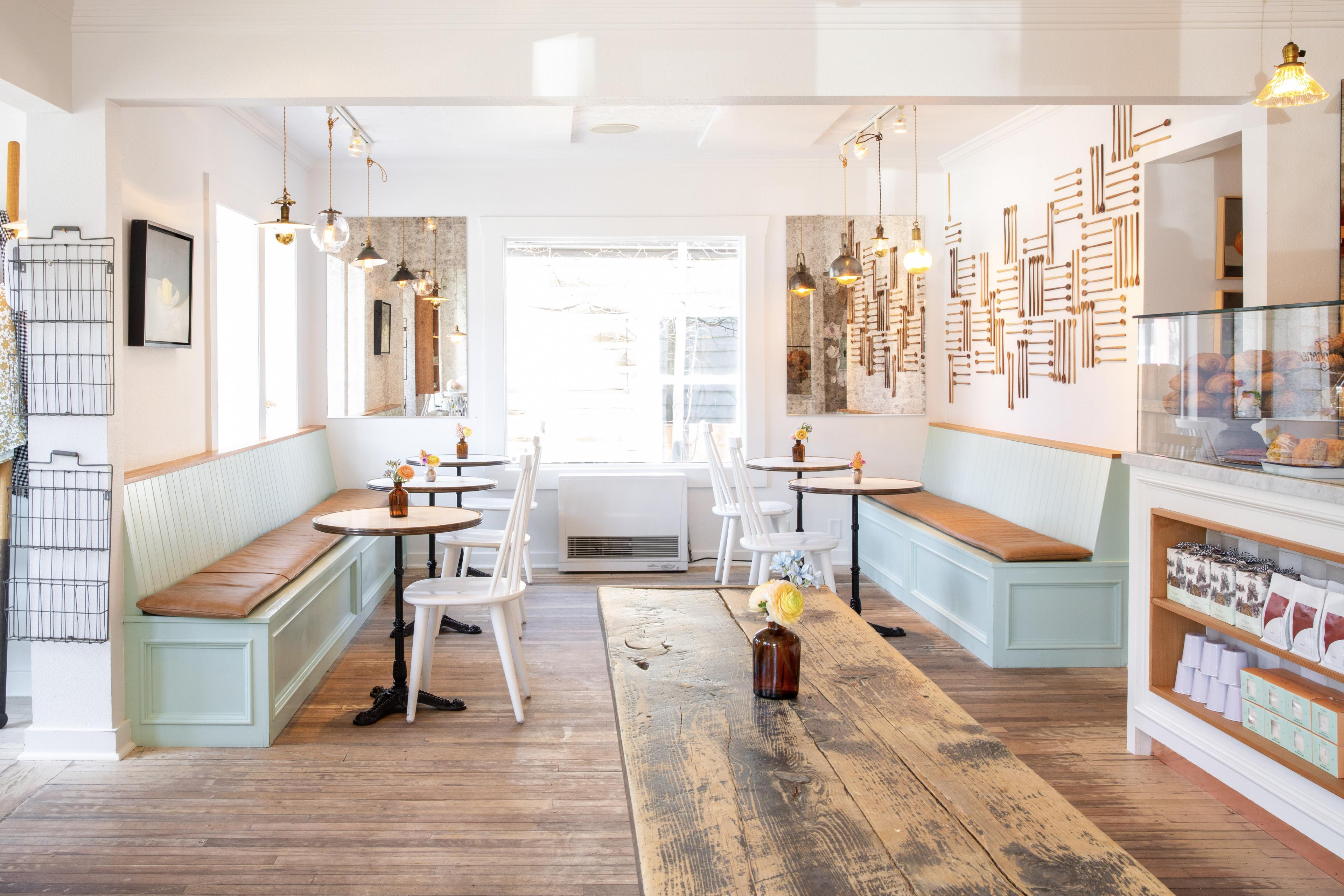 light filled bakery interior with pastel blue benches and wooden tabletops