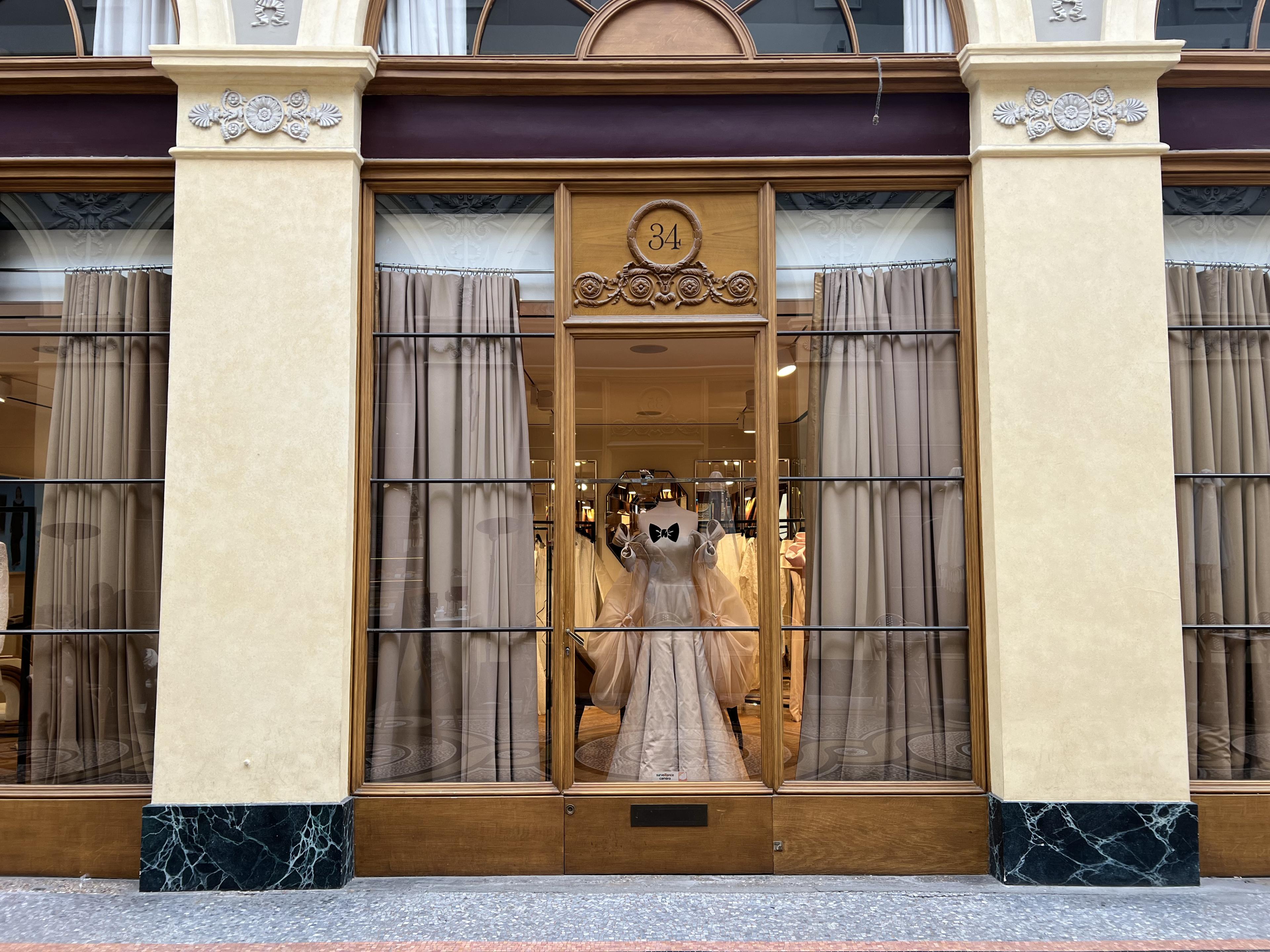 window display with a fancy dress and polished wood window frames