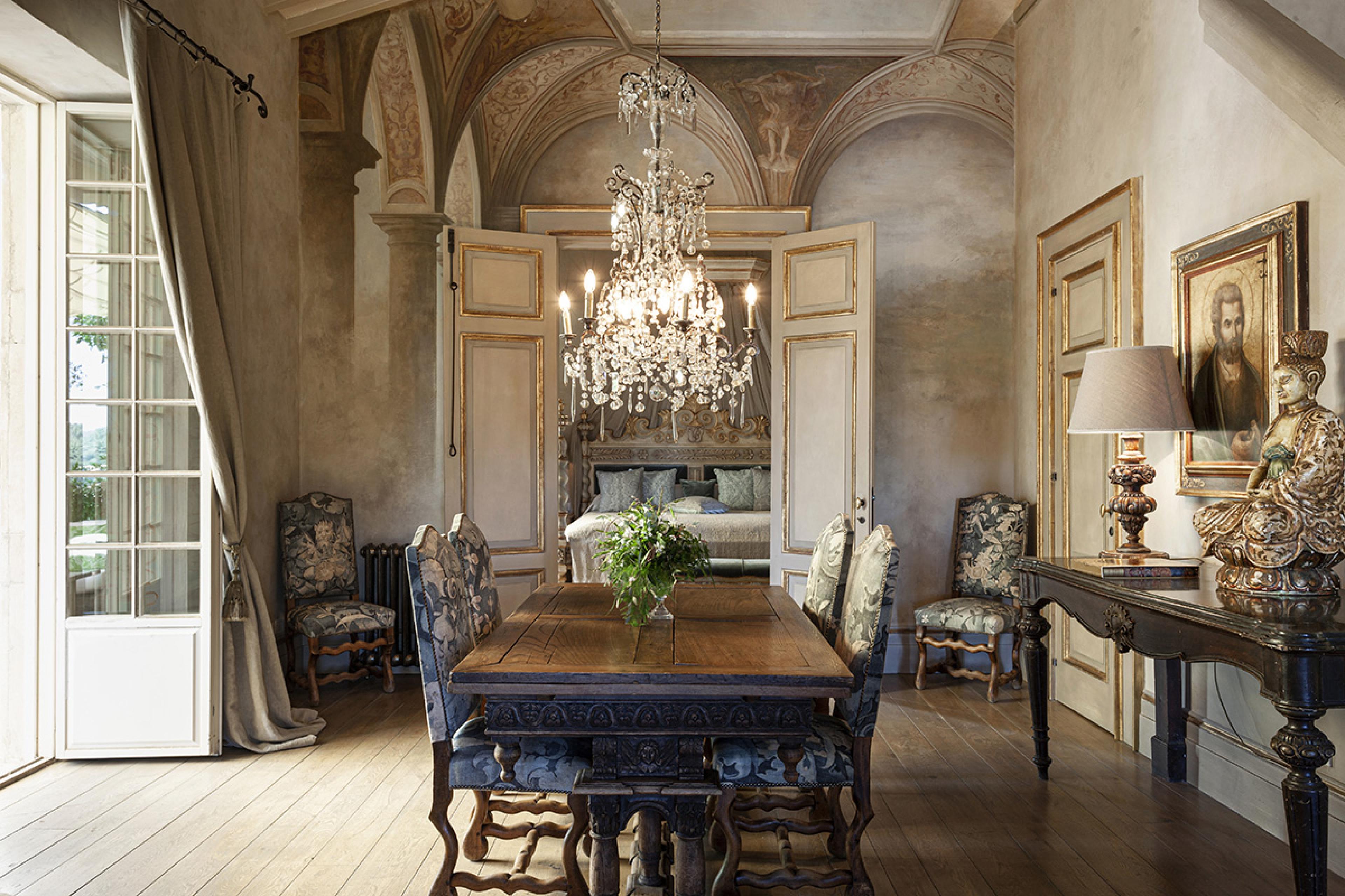 romantic rustic dining room with stone walls and a crystal chandelier