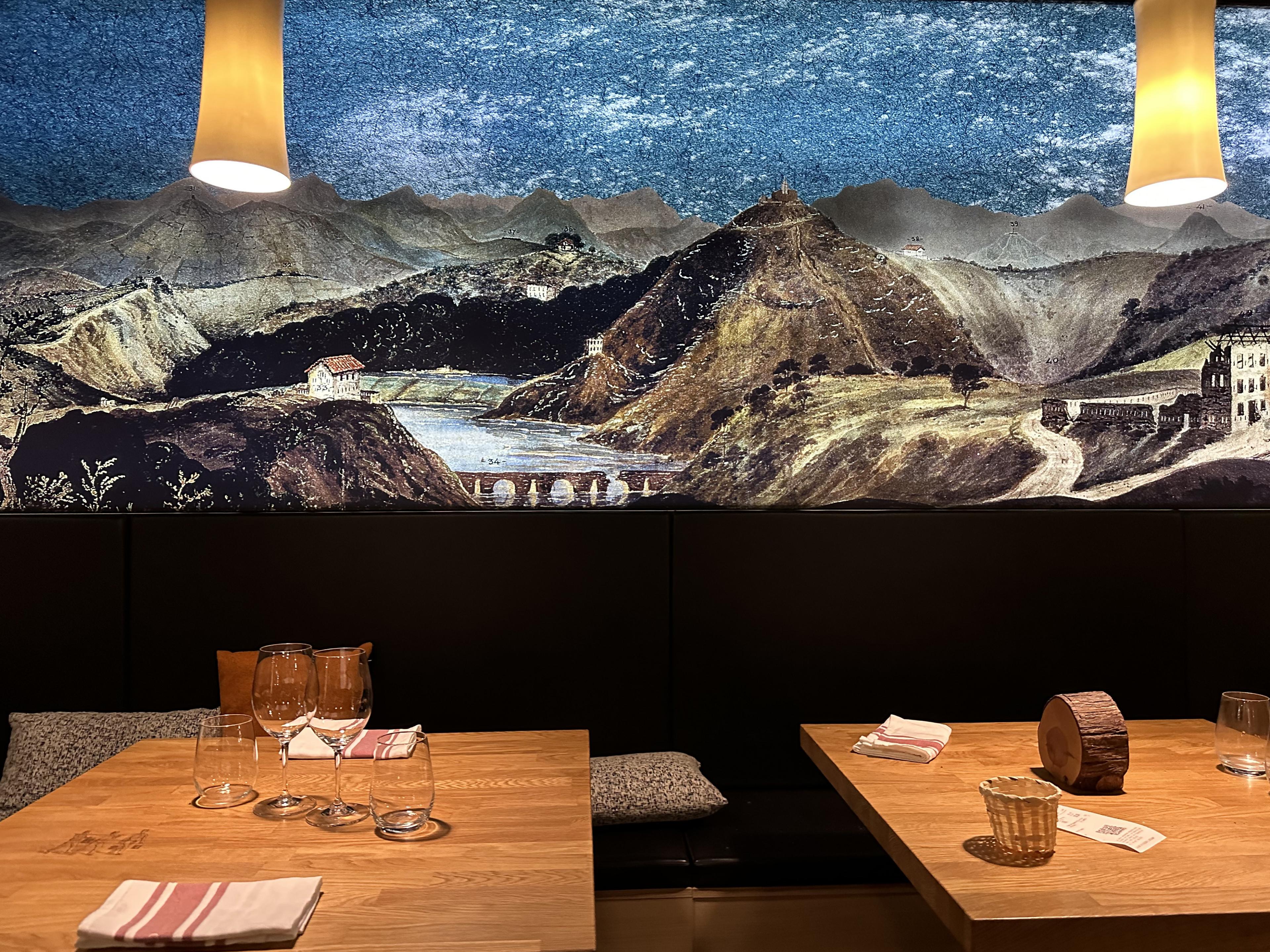 restaurant table with a starry night over mountains painted on the wall
