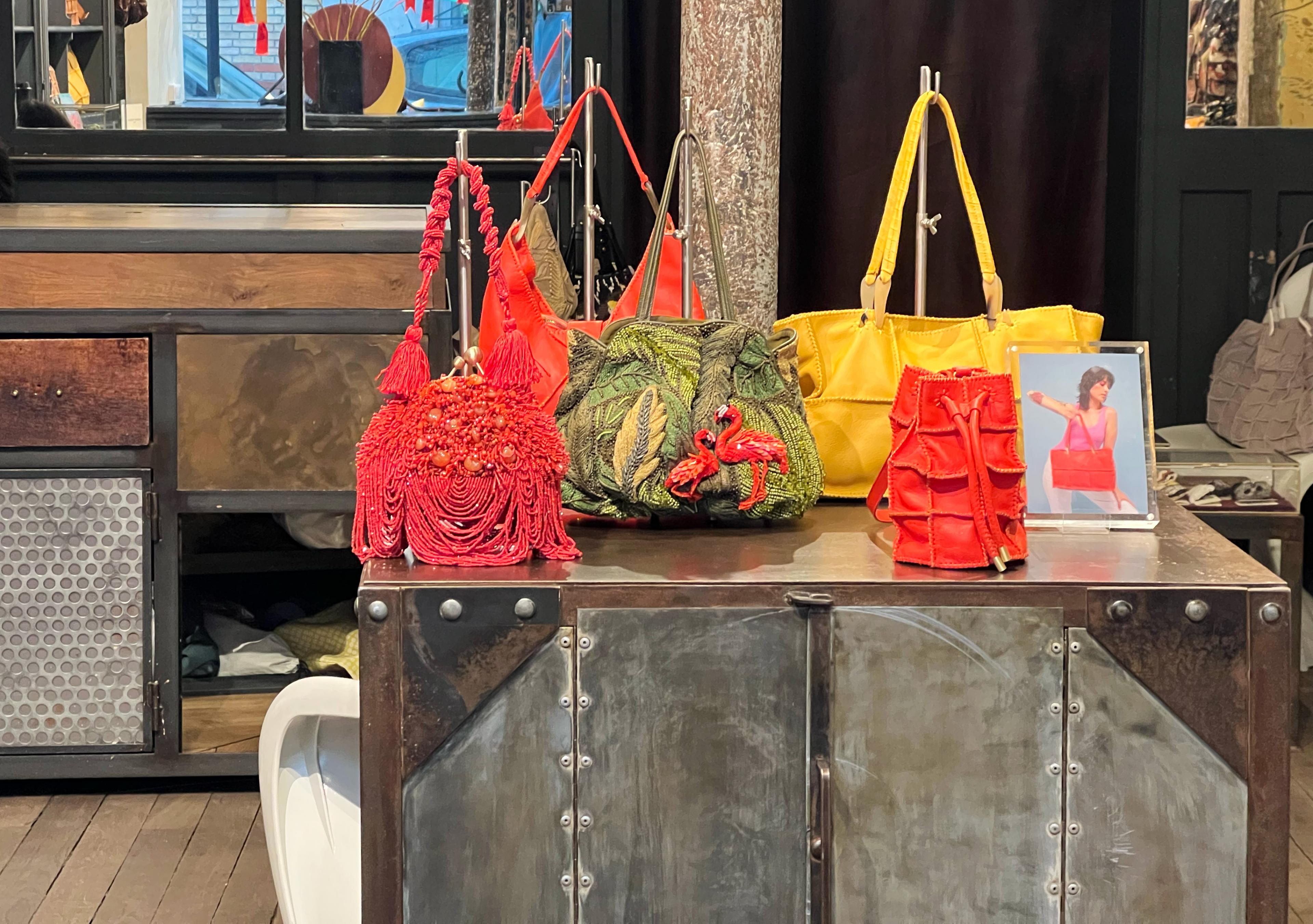 colorful, unusual handbags on a wood and metal cabinet